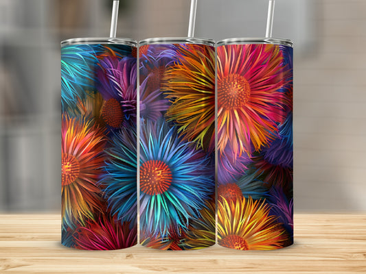 Three colorful floral tumblers with straws displayed on a wooden surface.