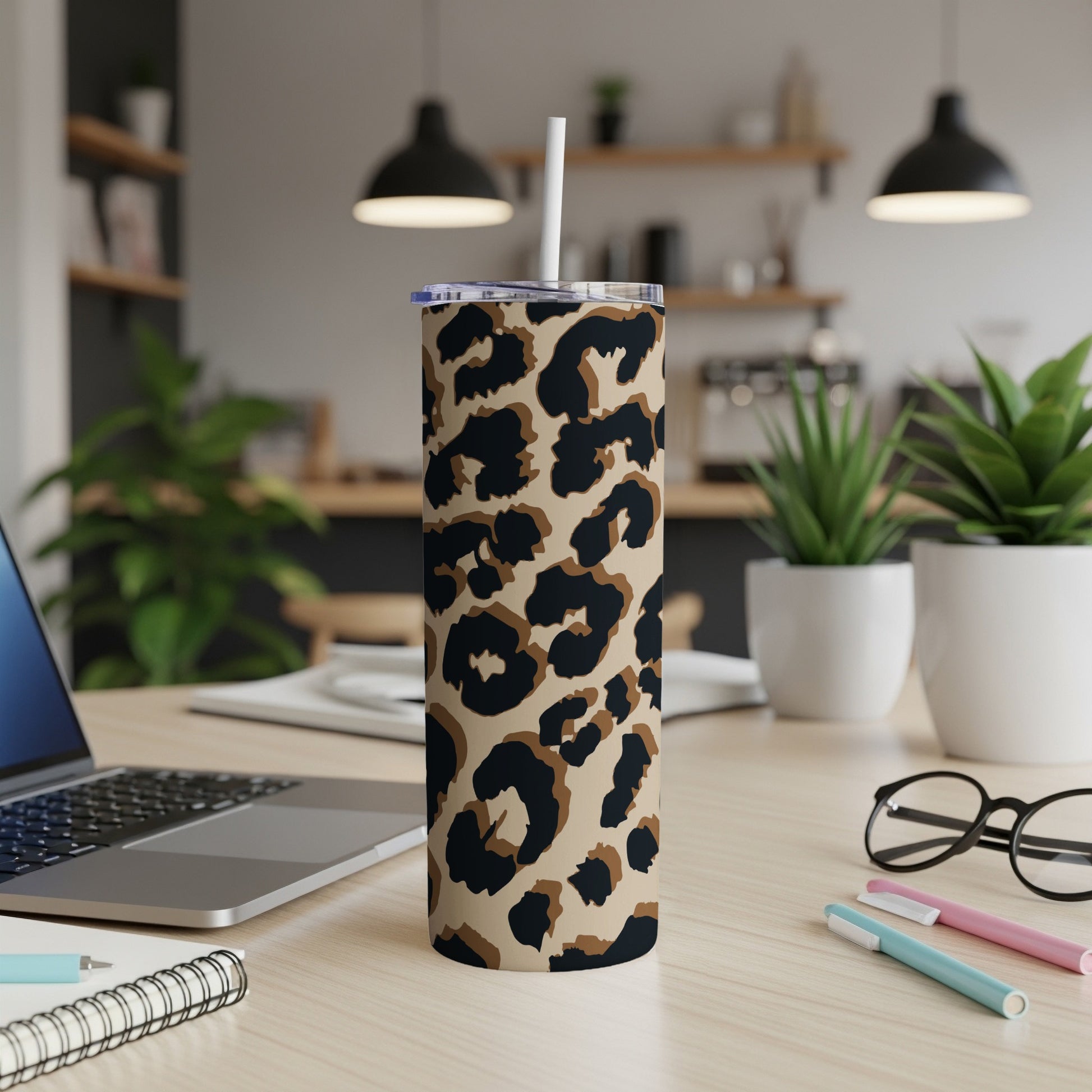 Tumbler with leopard print pattern and white straw on a desk.
