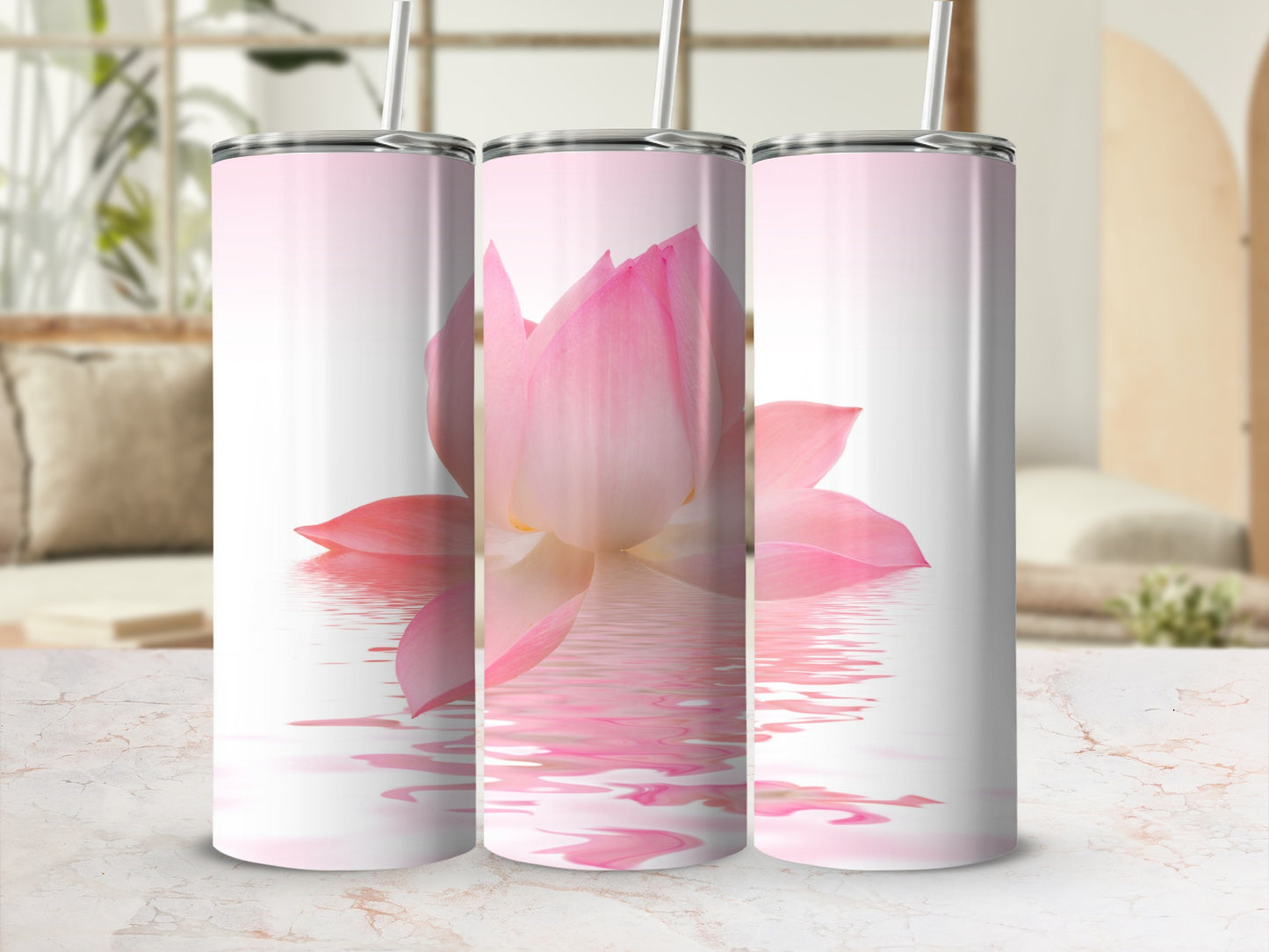 Three tumblers with a pink lotus flower reflecting on water.