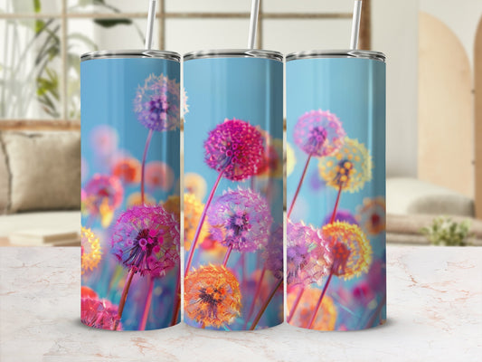 Three tumblers featuring colorful dandelion seed heads against a blurred blue and green background.