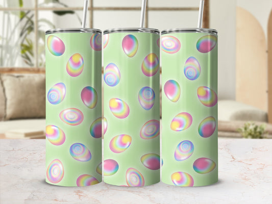Pastel Easter eggs on a light green patterned tumbler with straws.