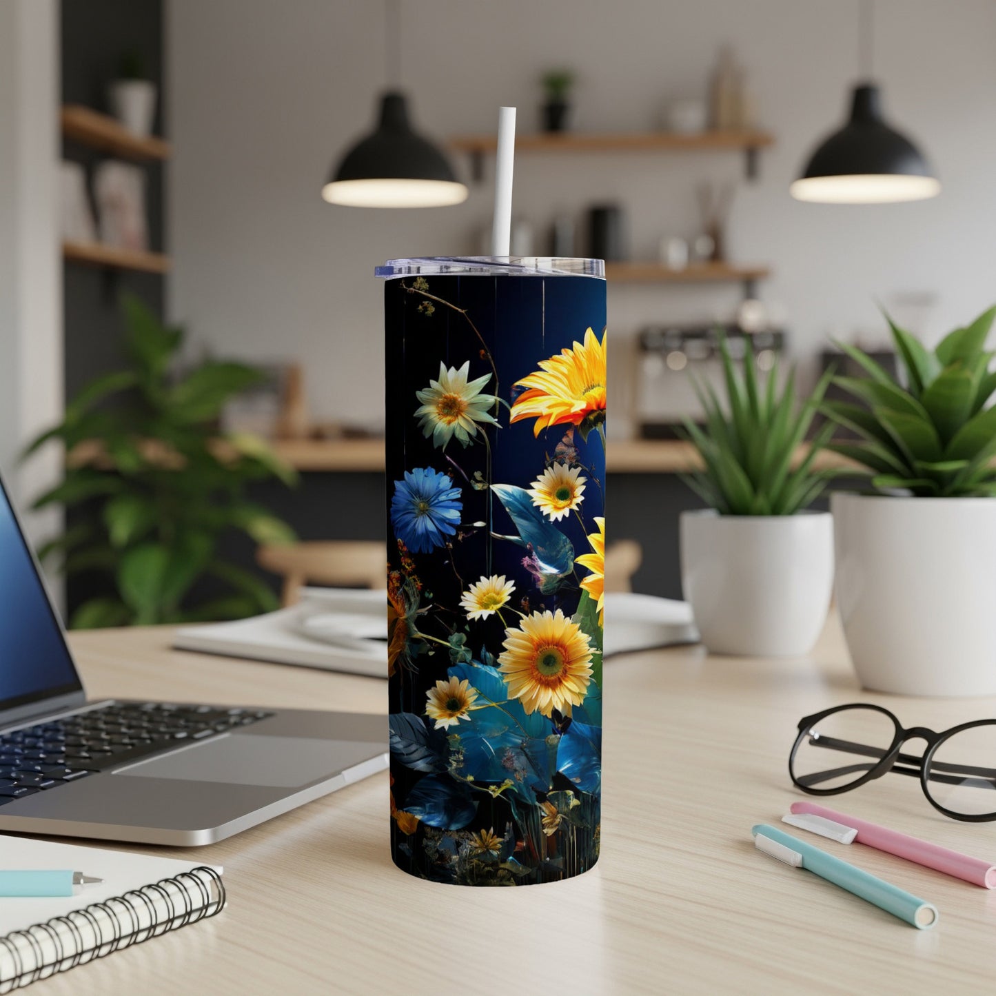 Dark tumbler with vibrant floral pattern on a desk.