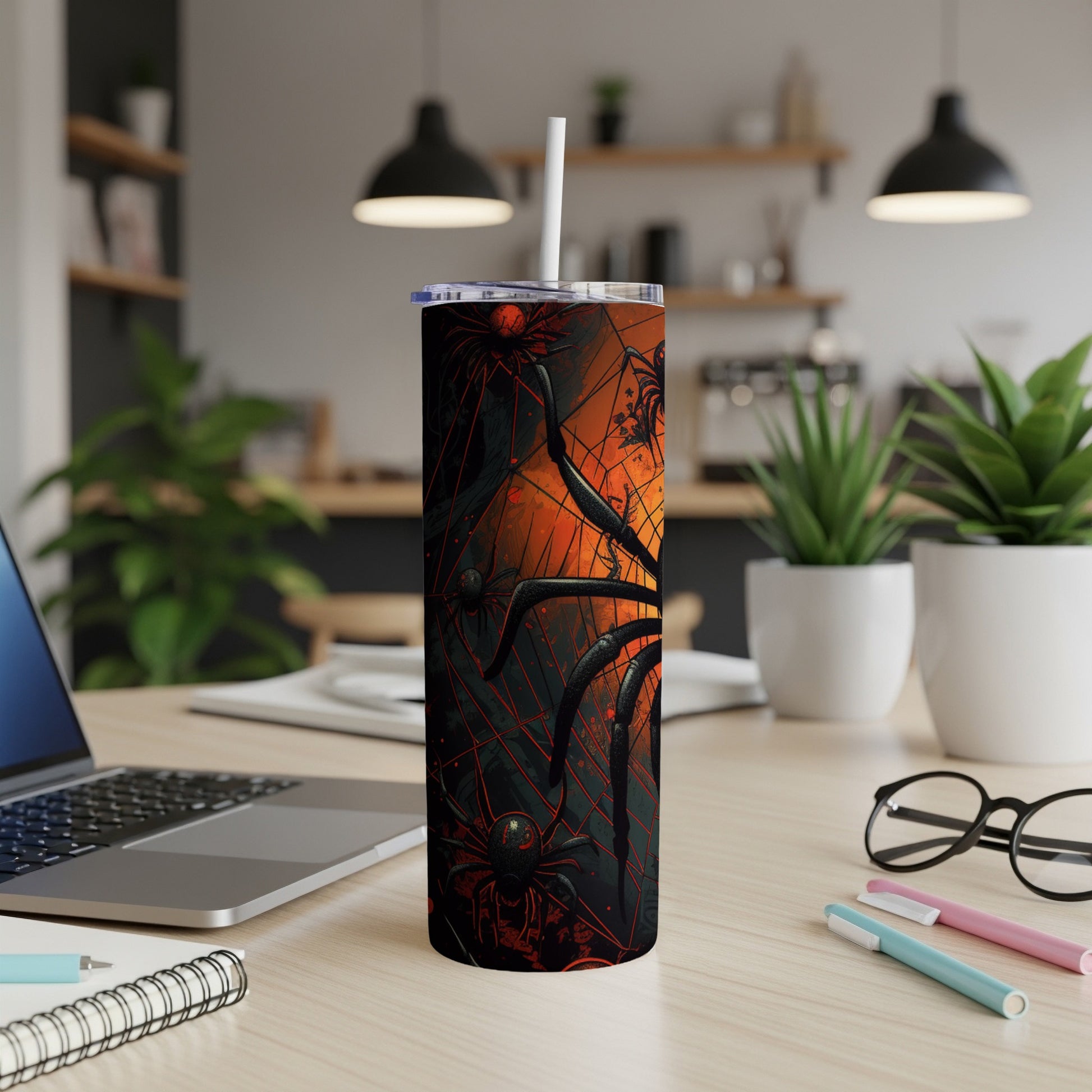 Tumbler with black and red spiders and cobweb design, with white straw.