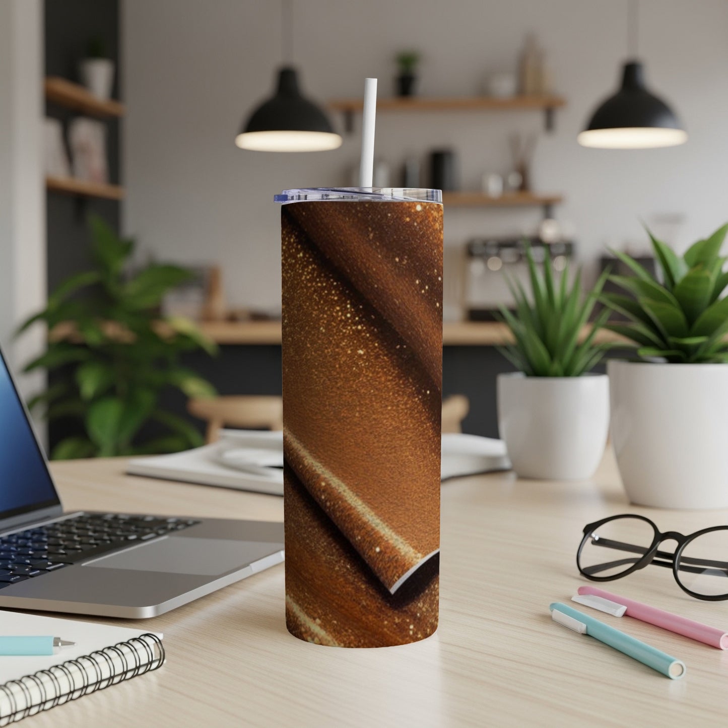 Brown sparkly tumbler with a white straw on a desk.