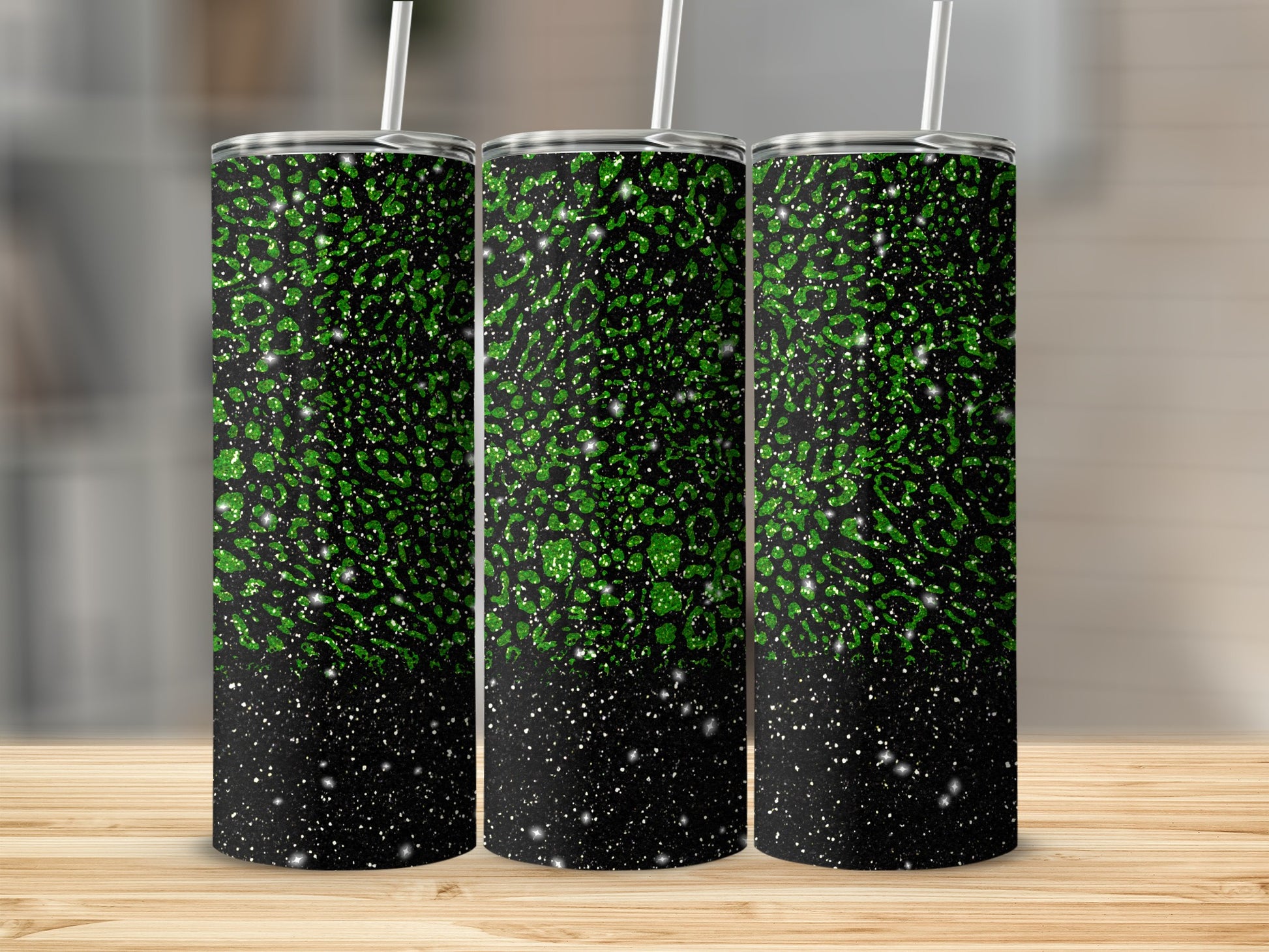 Three tumblers with green glitter speckles on black background.