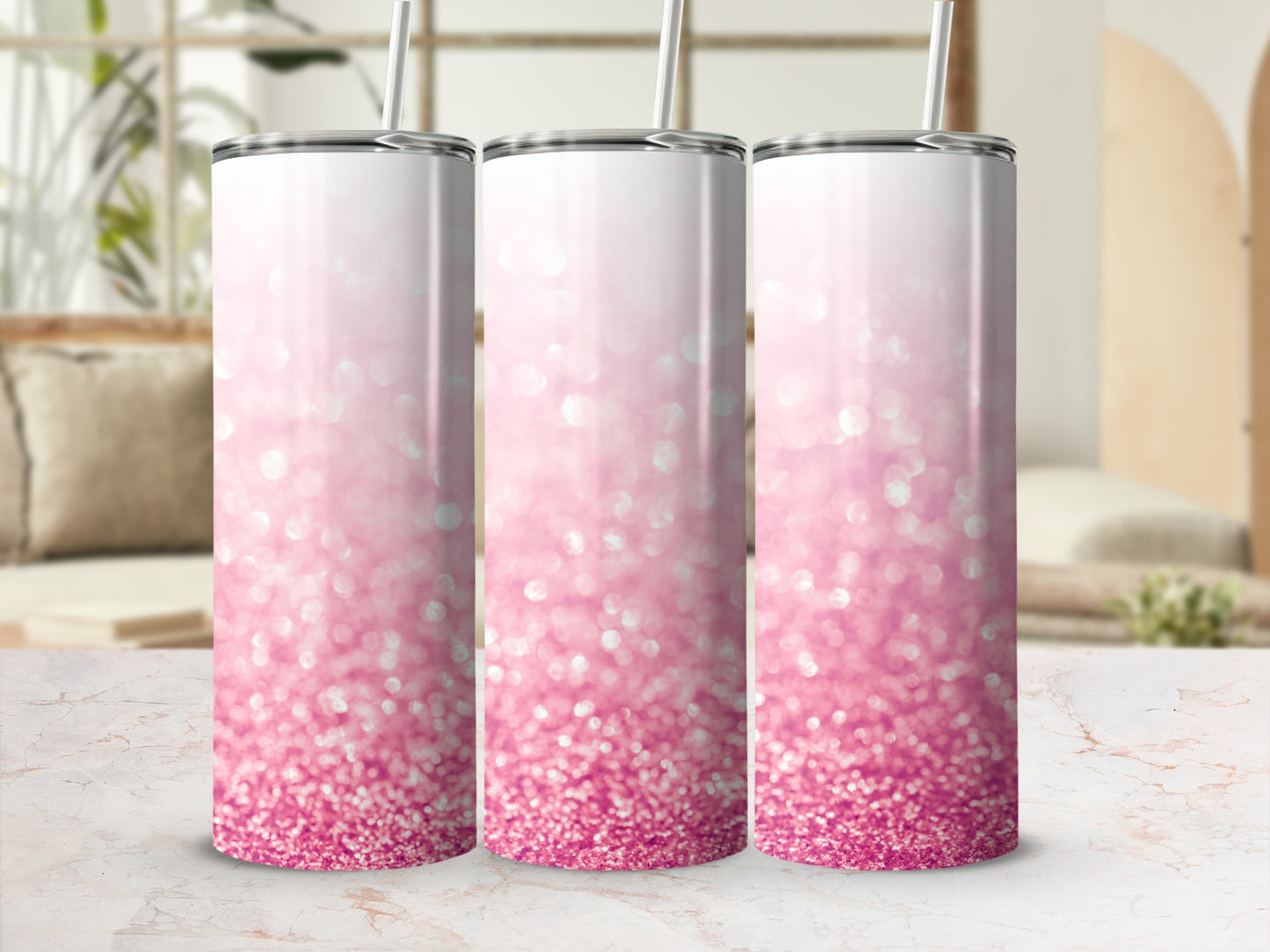 Three pink glitter tumblers with straws in a studio setting.