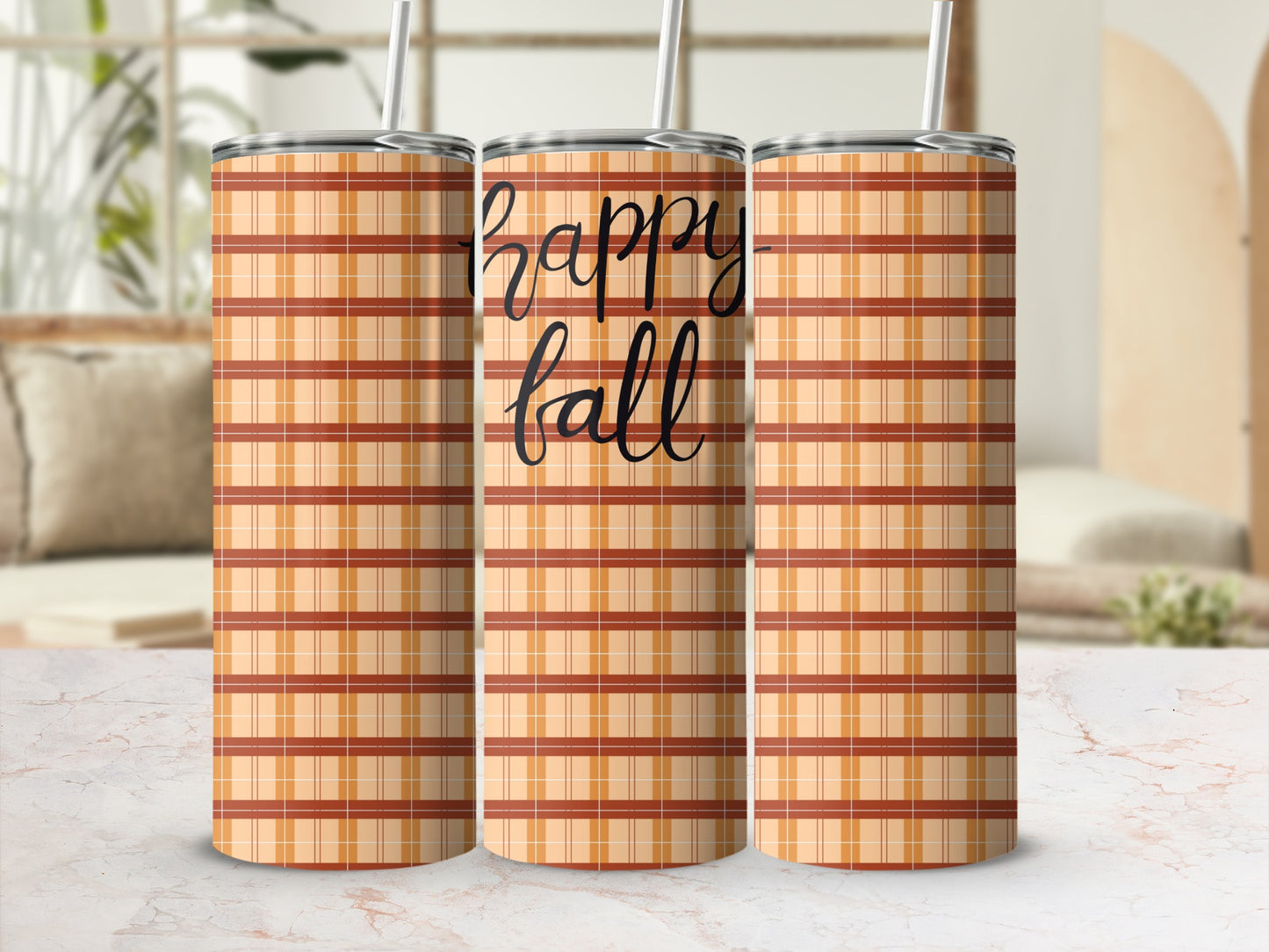 Three plaid tumblers with "happy fall" text on a marble surface.