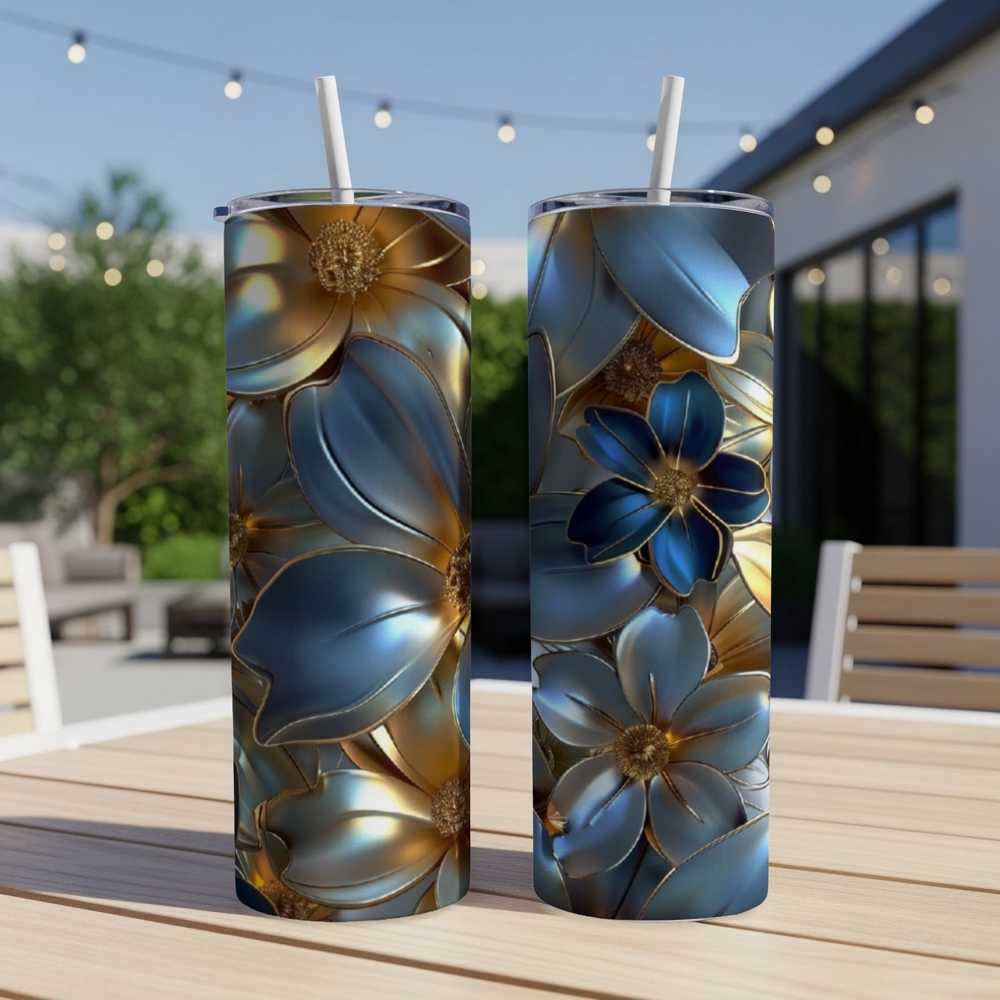Two tall, slender tumblers with blue and gold floral designs sit on a wooden table outdoors.