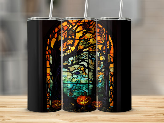 Black tumbler with stained glass design of haunted trees and pumpkins.