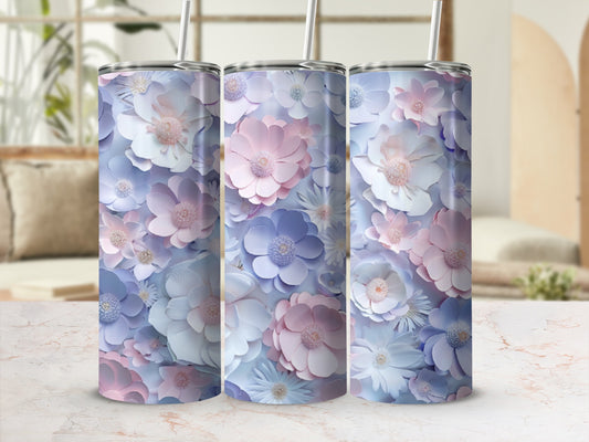 Three pastel floral tumblers with straws on a marble countertop.
