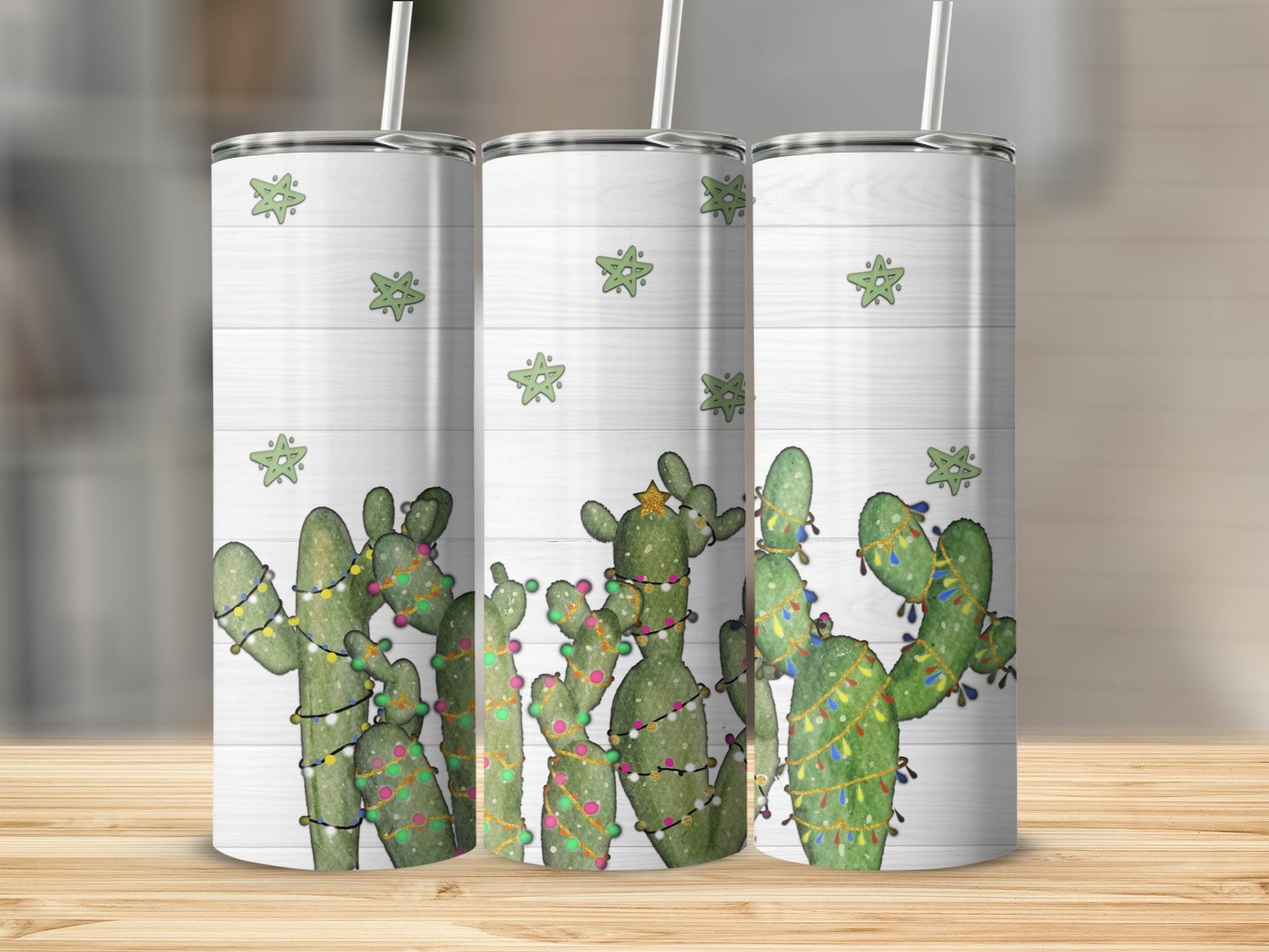 Three tumblers with Christmas lights and stars on a wood grain background.