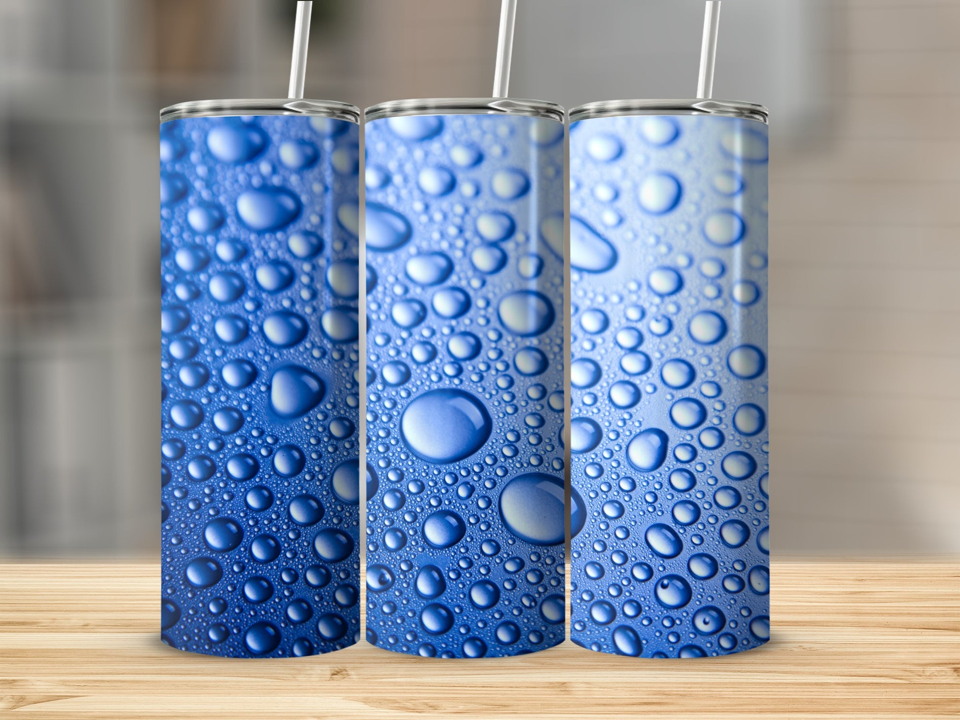 Three tumblers with a blue water drop pattern on a wooden surface.