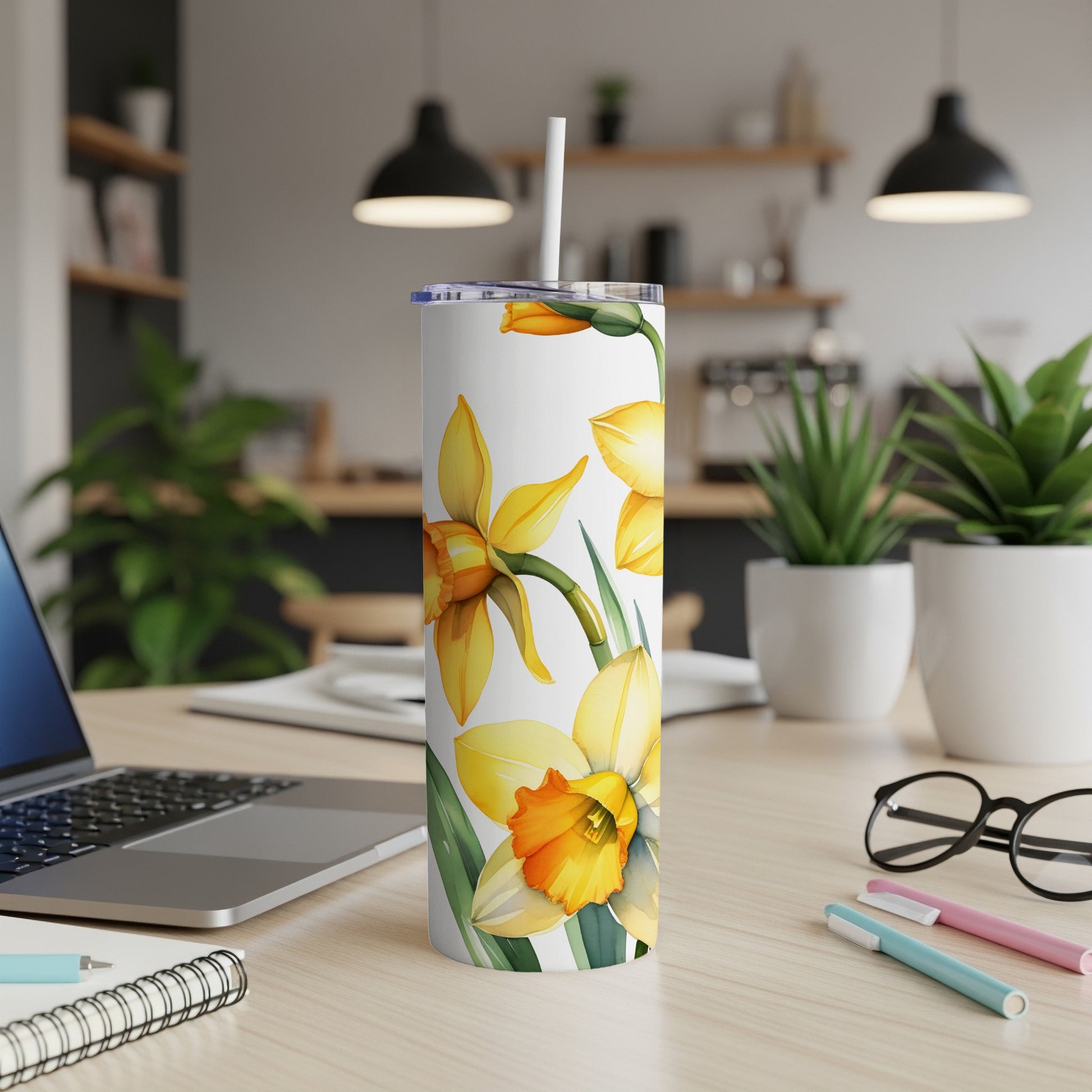 White tumbler with yellow daffodils and green leaves.