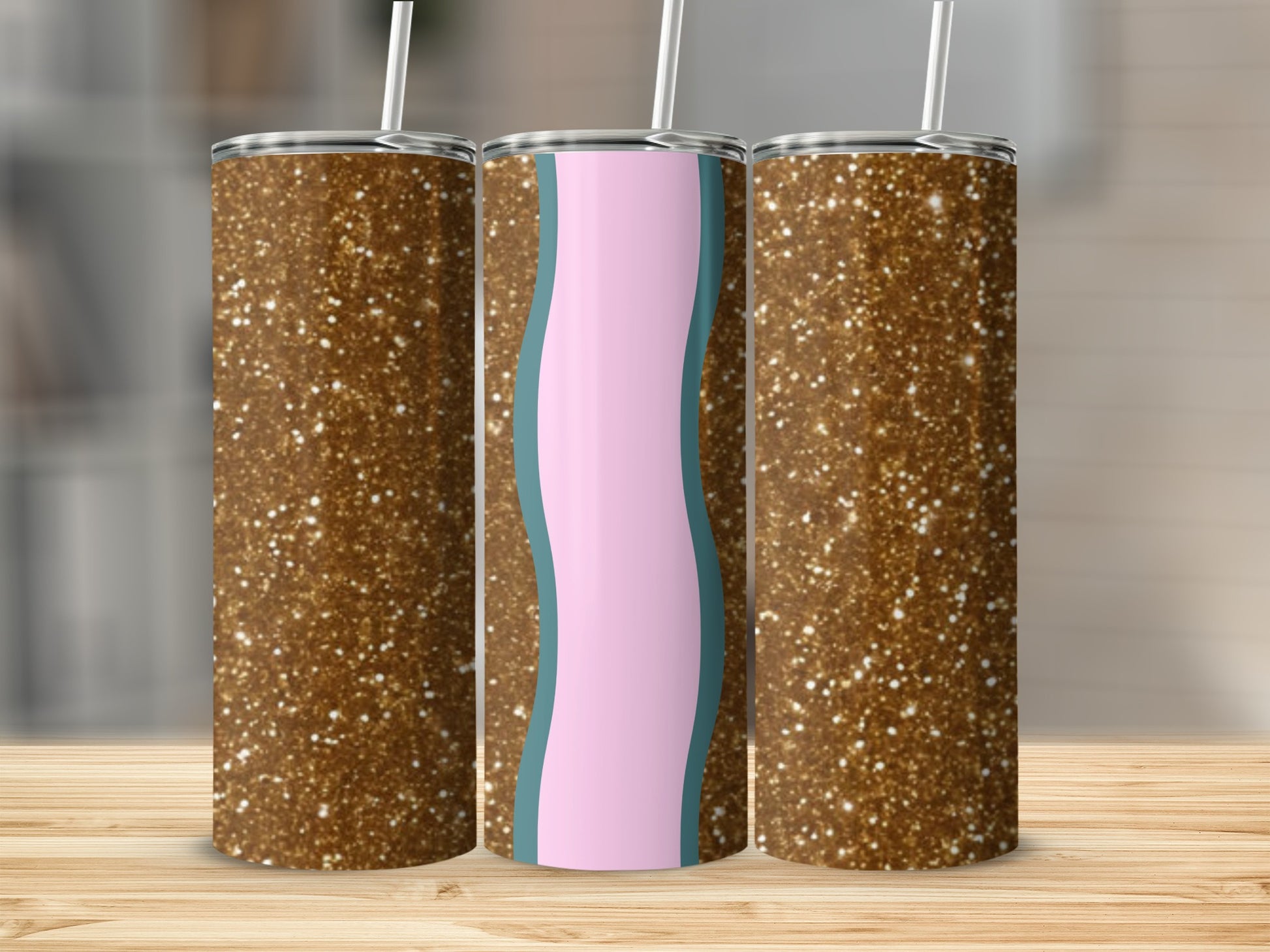 Three glitter-covered tumblers with straws, one with pink and blue wave design.