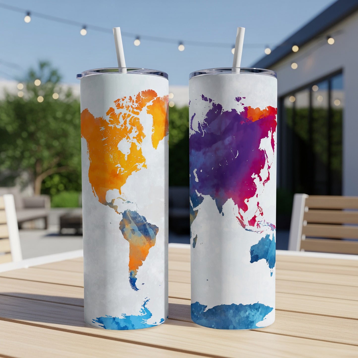 Two tumblers with colorful watercolor world map designs on a wooden table.