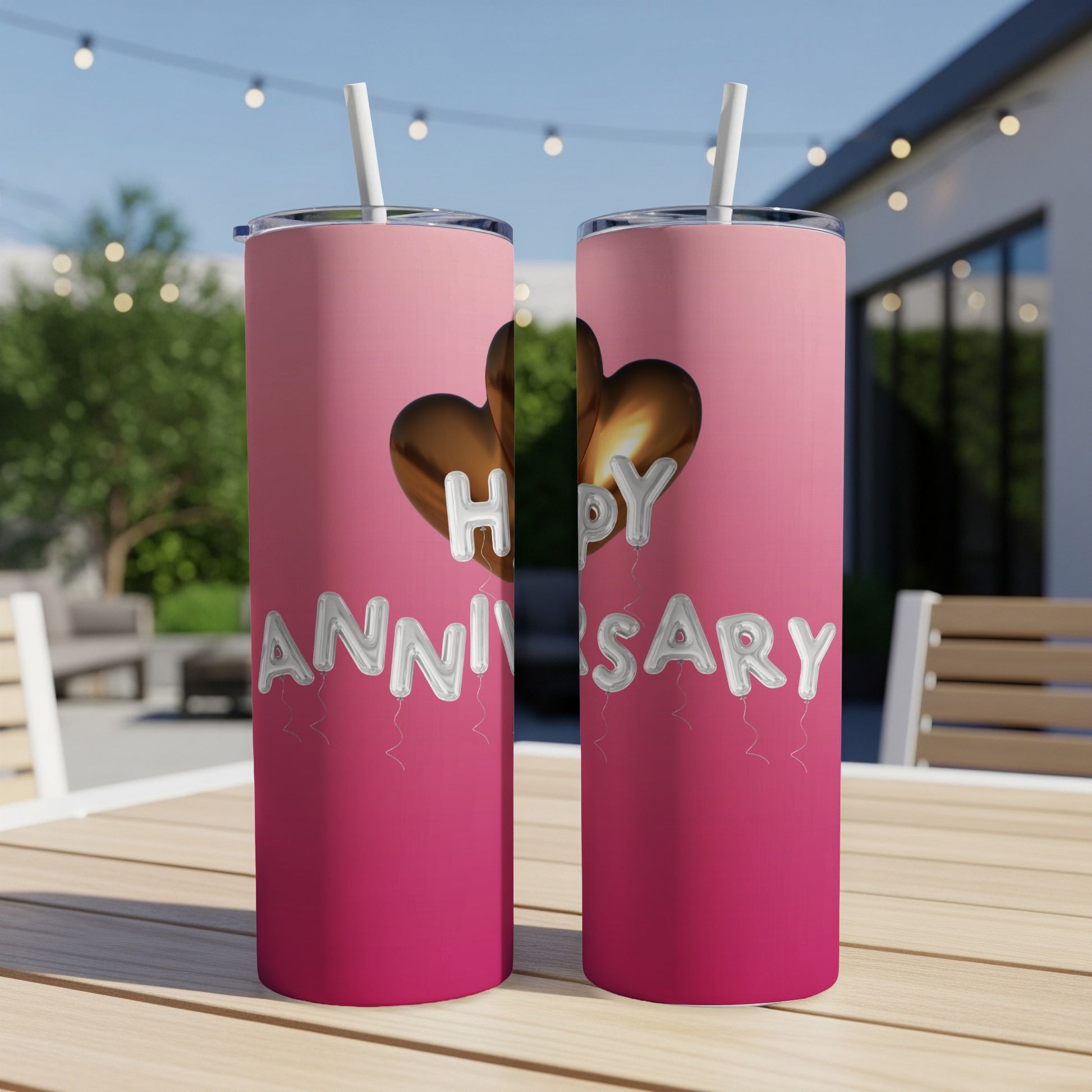 Two pink tumblers with "Happy Anniversary" in balloon lettering.