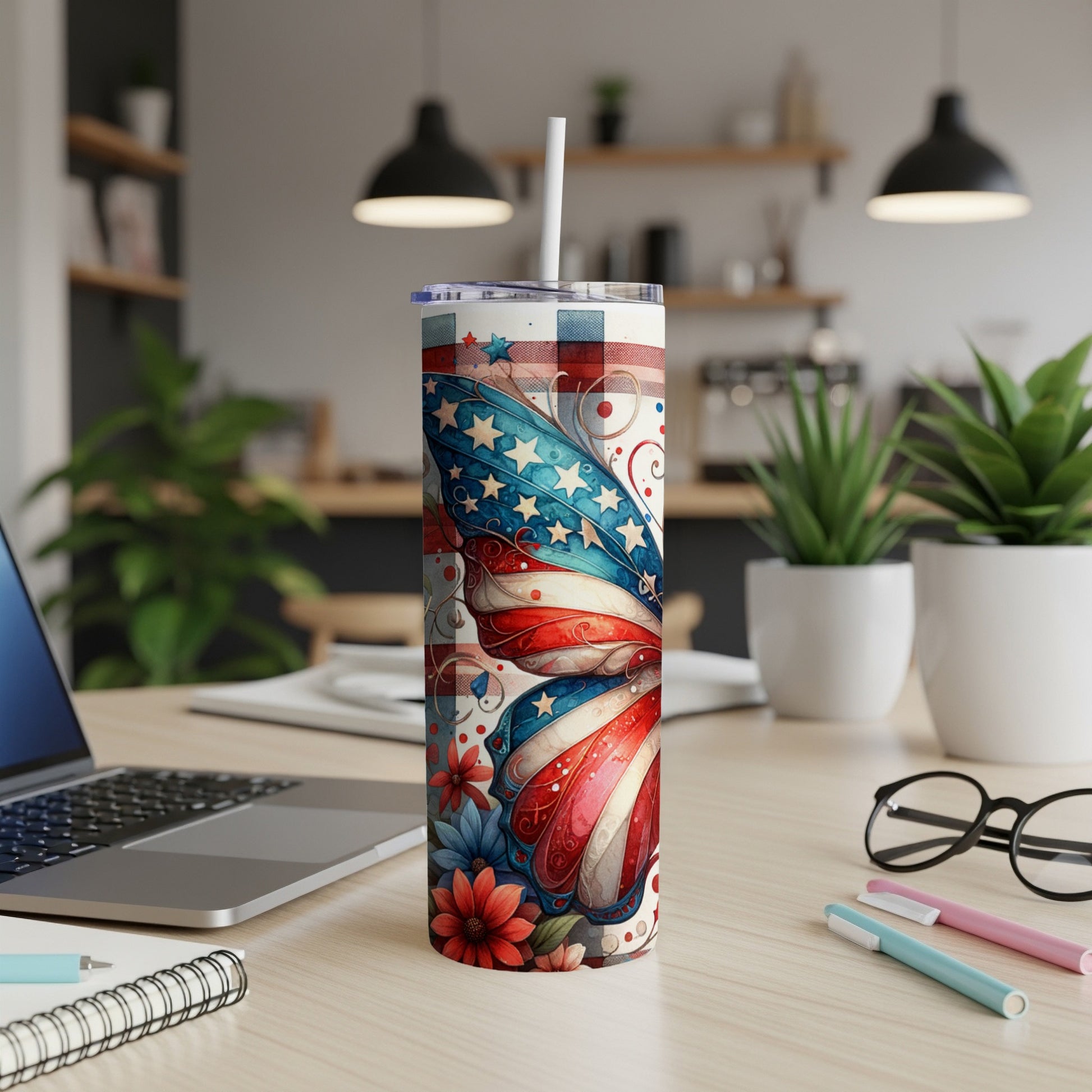 American flag butterfly tumbler with straw on a desk.