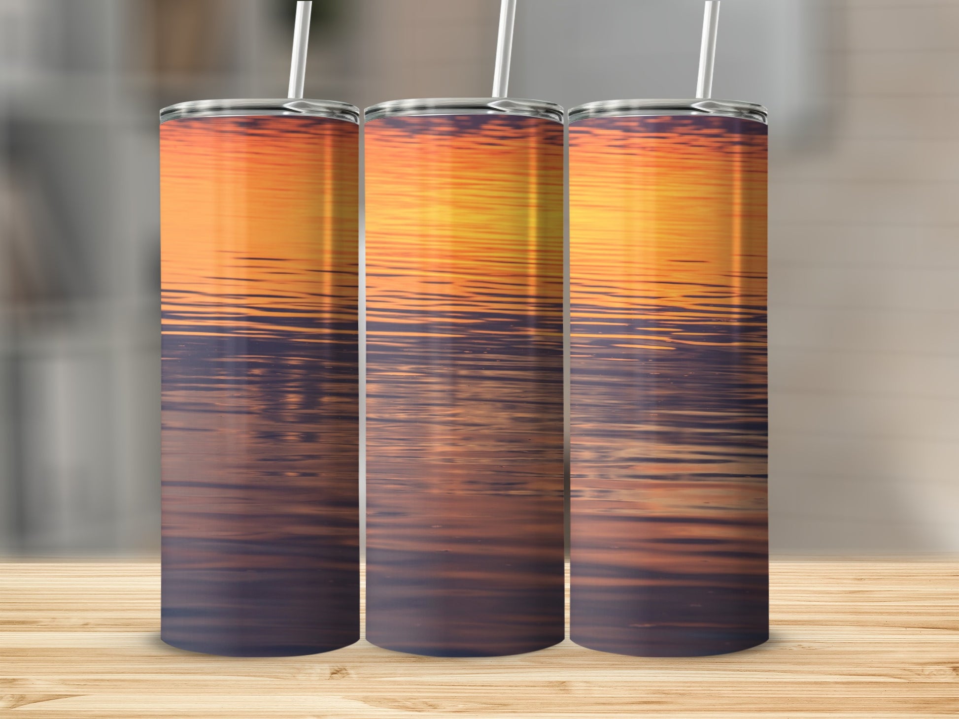 Three tumblers with a sunset reflection on water design.