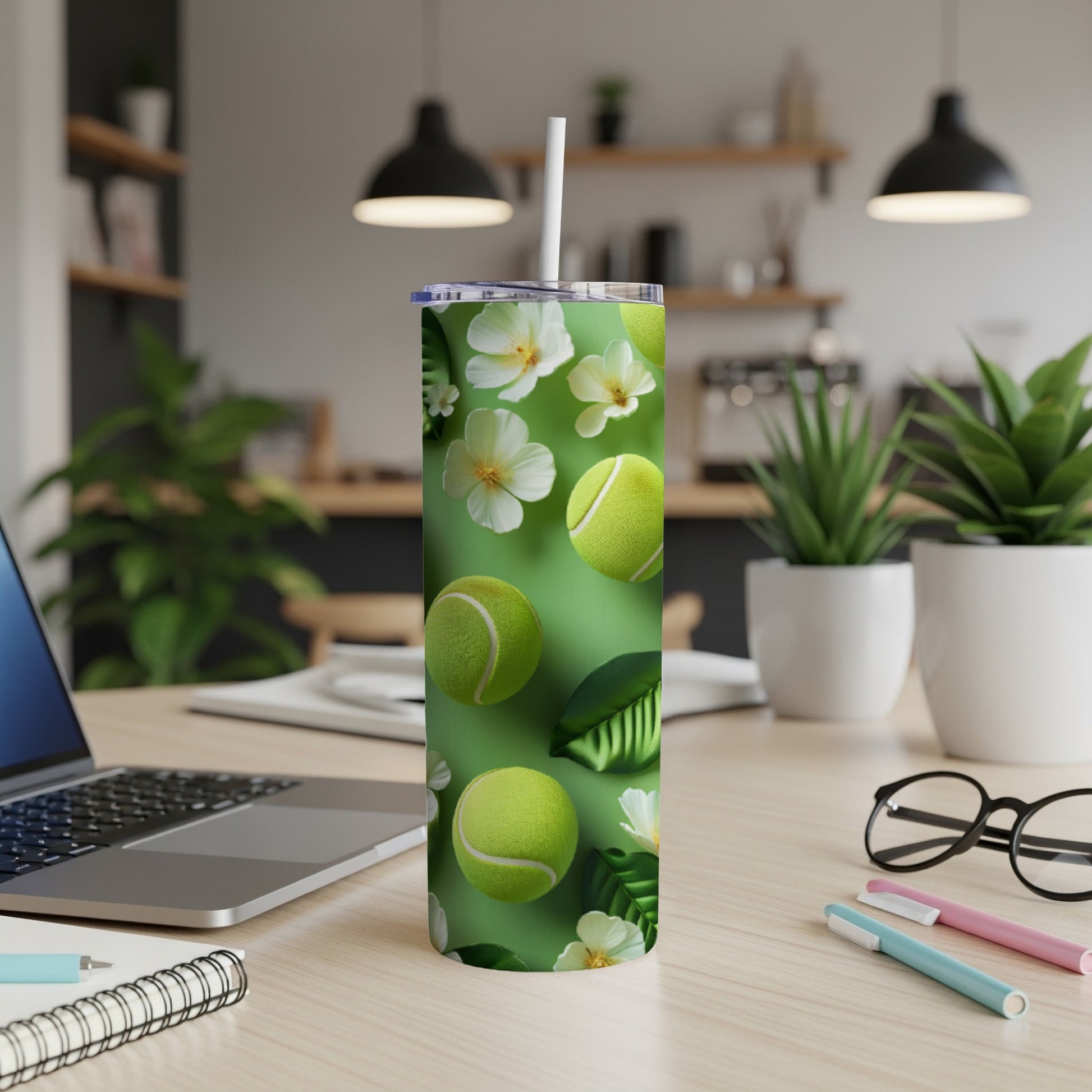 Green tumbler with tennis balls, white flowers, and green leaves design.