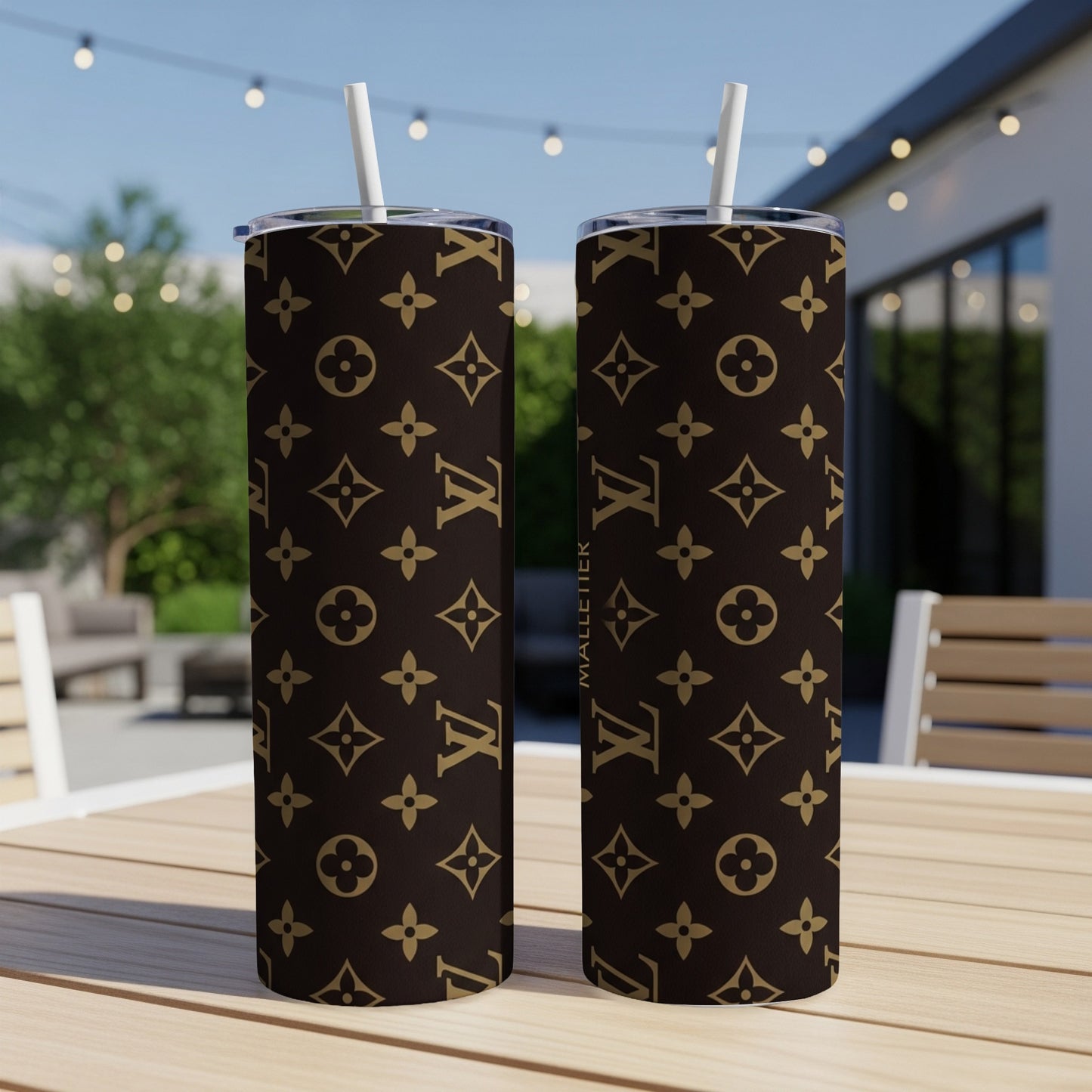 Two brown tumblers with repeating LV monogram pattern, sitting on a table.