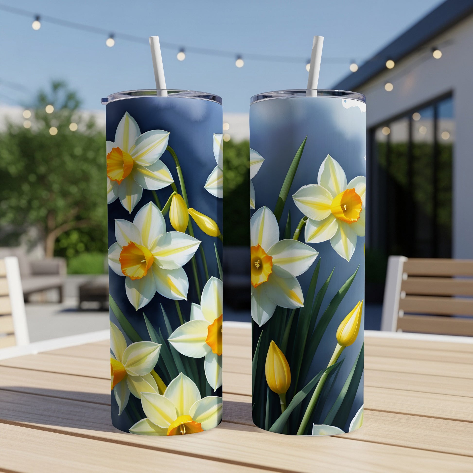Two tumblers with a close-up floral daffodil print, on a table outdoors.