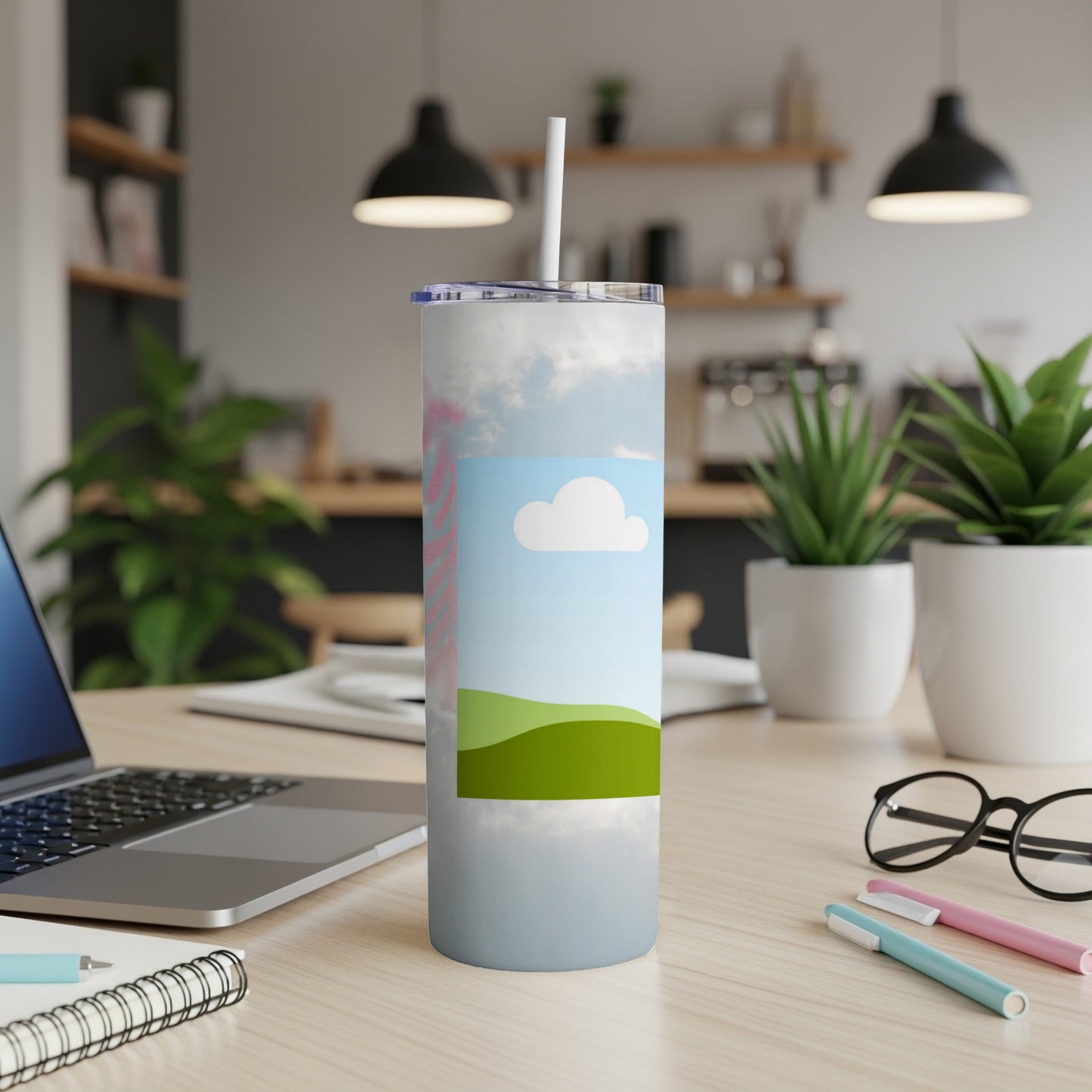 Tumbler with a sky and rolling green hills design, with a straw.