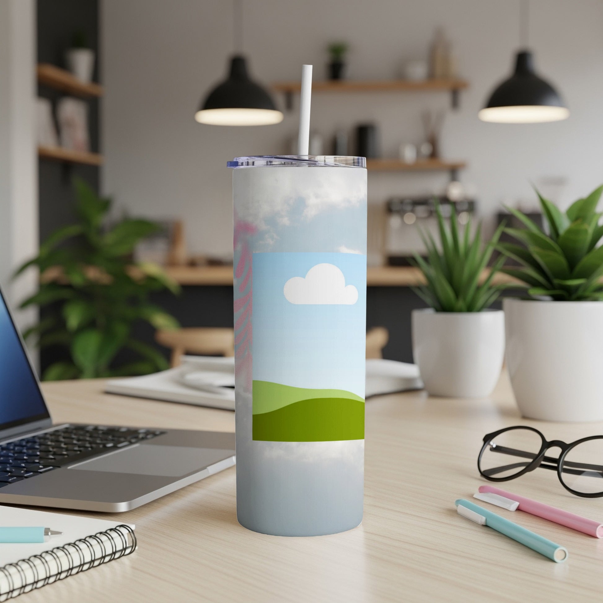 Tumbler with a sky and rolling green hills design, with a straw.