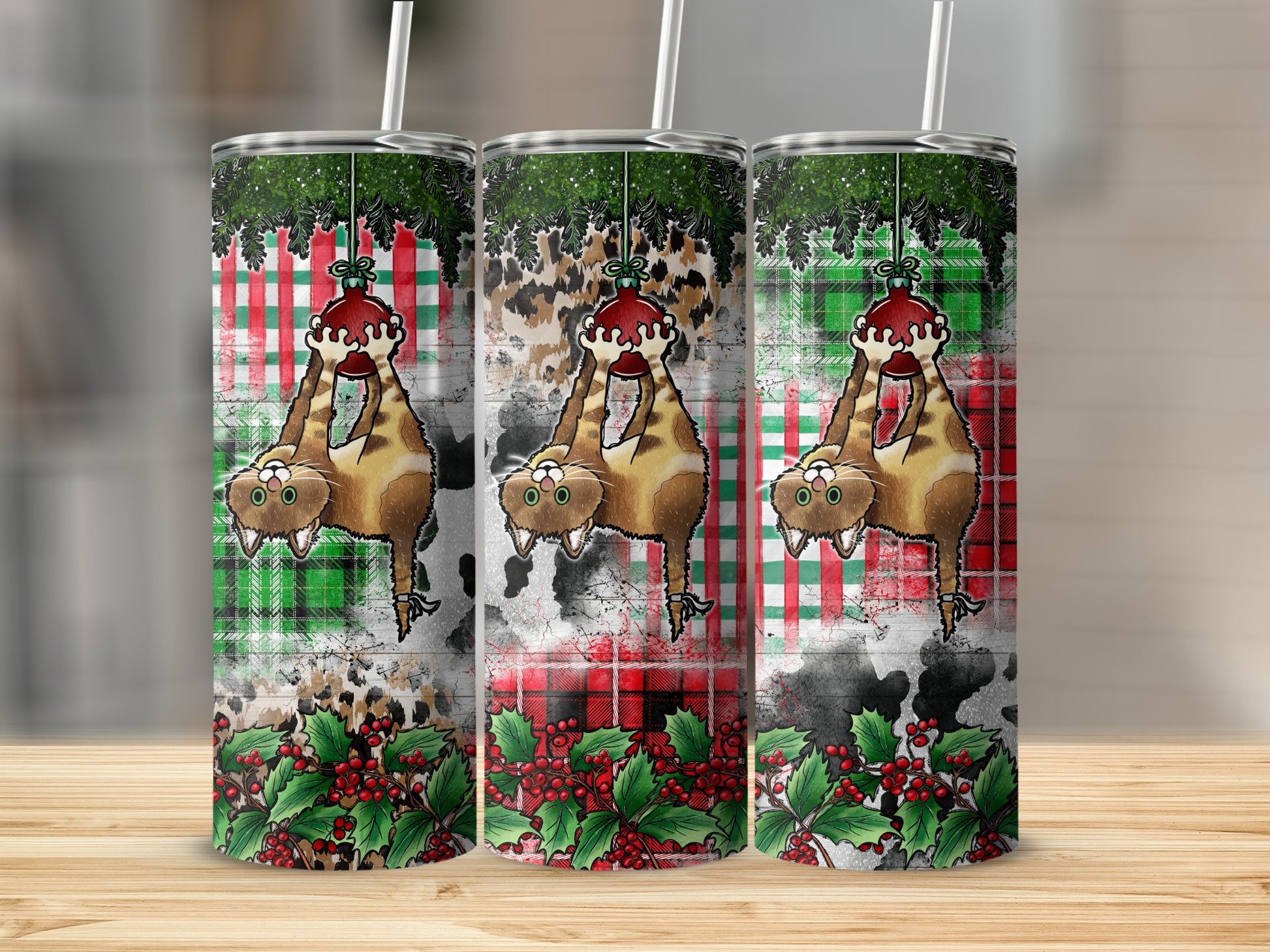 Three tumblers featuring a cat hanging from a branch with holly.