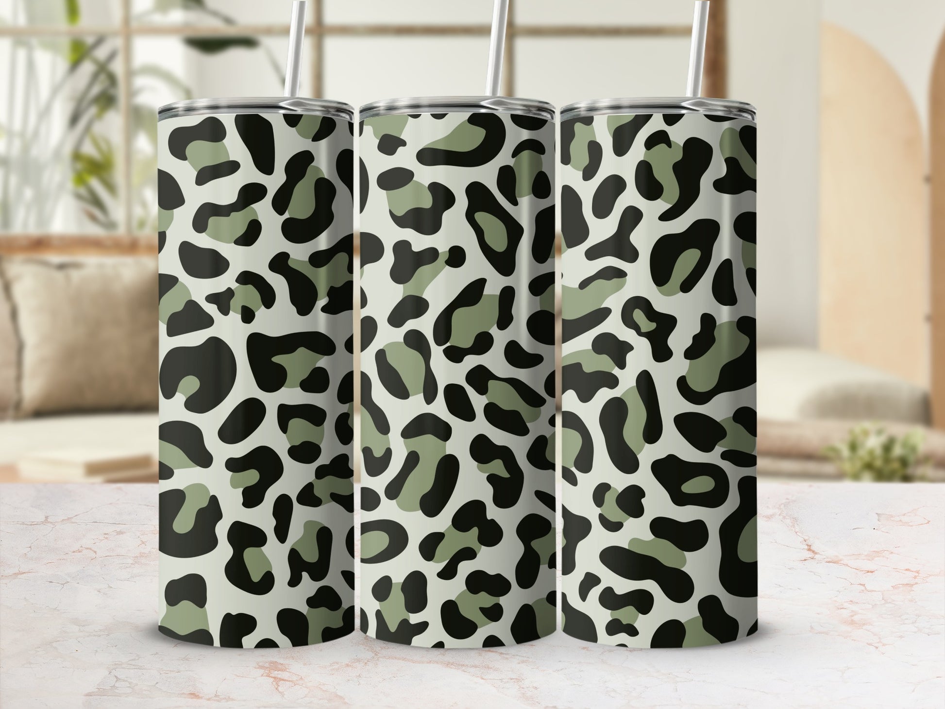 Three tumblers with a camouflage leopard print pattern and gray straws.