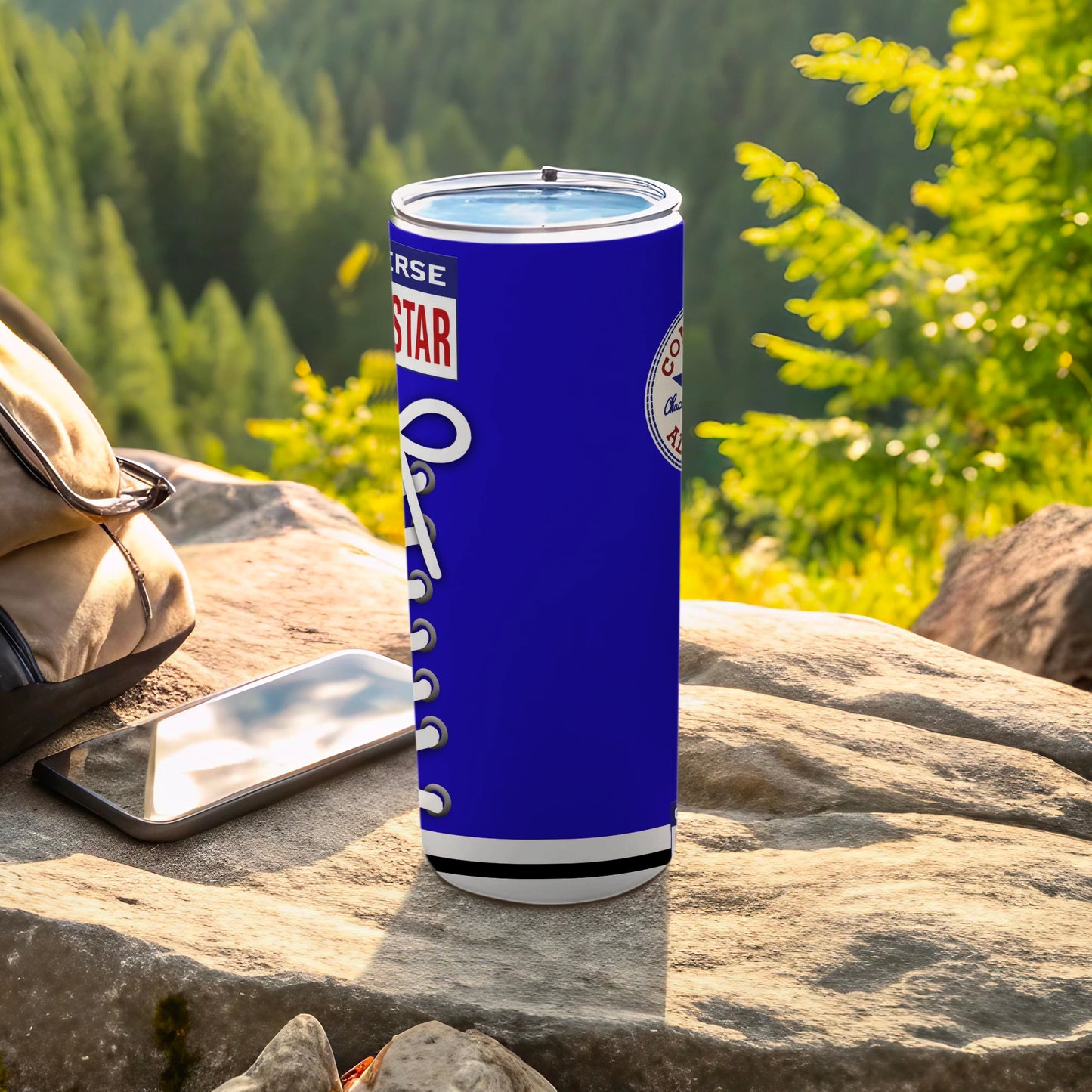 Blue Converse tumbler with white laces and logo on a rock.