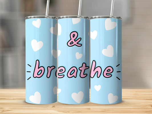 Blue tumbler with white hearts and text " & breathe ".