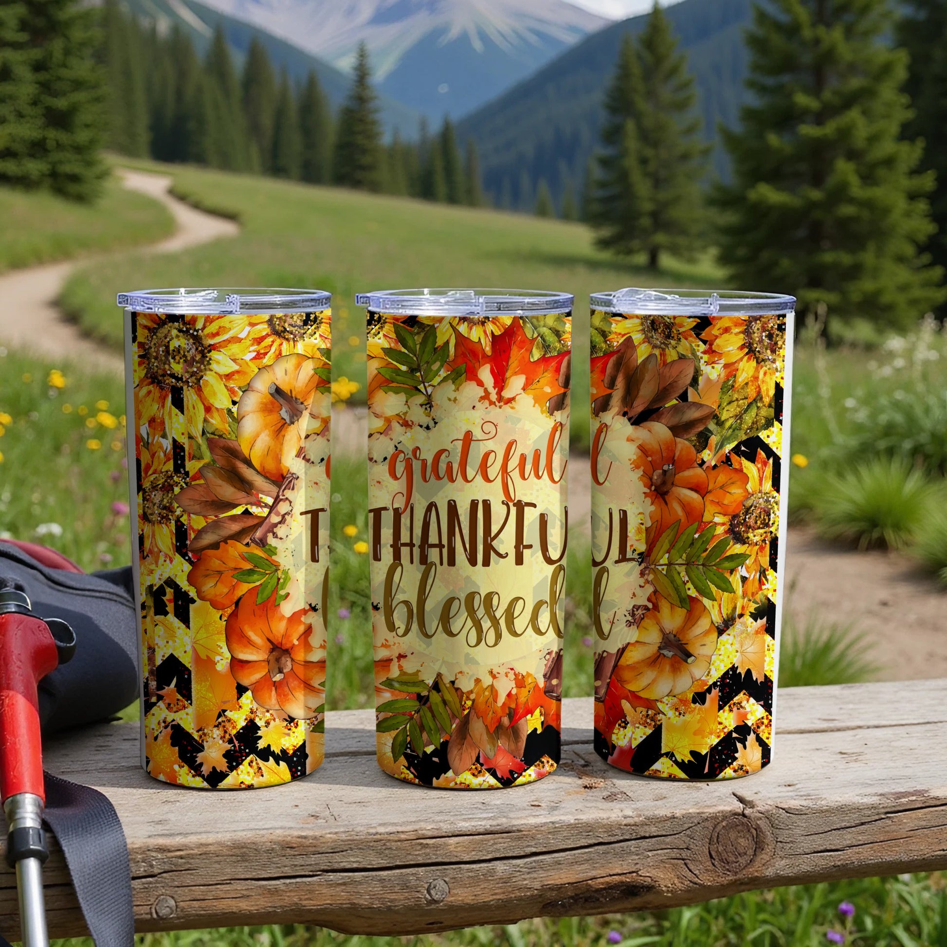 Three tumblers with fall leaves, pumpkins, and sunflowers, one says "grateful thankful blessed."