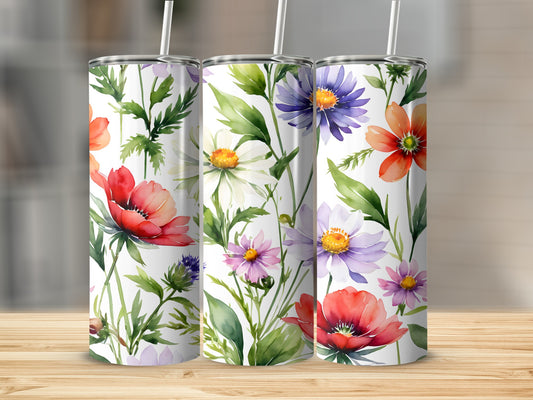Three tumblers with colorful floral watercolor patterns on a wooden surface.