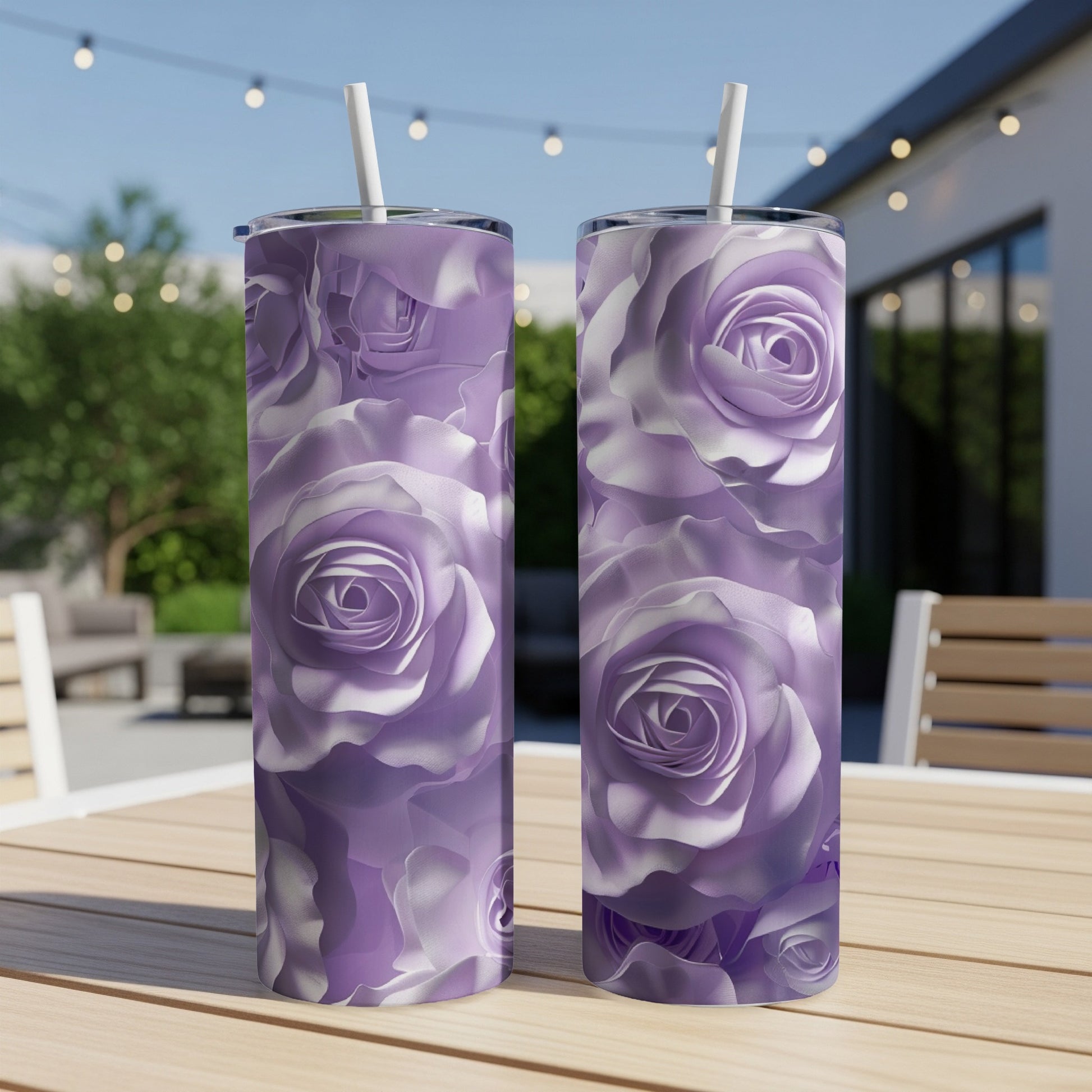 Two purple rose pattern tumblers with straws on a wooden table.