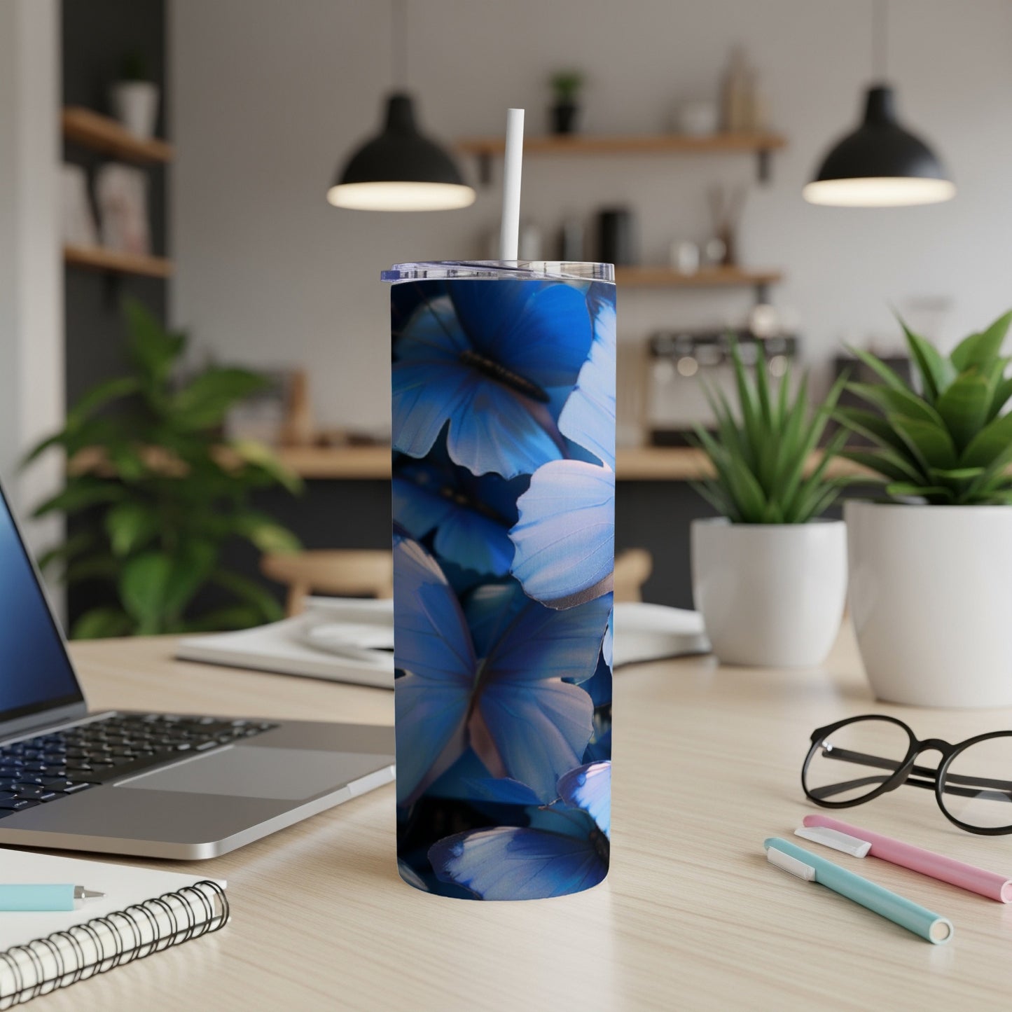 Blue butterflies on a tall tumbler with a straw.