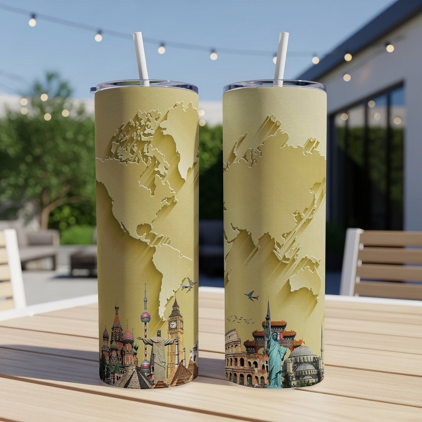 Two travel tumblers with world map and landmark designs, on a table outdoors.