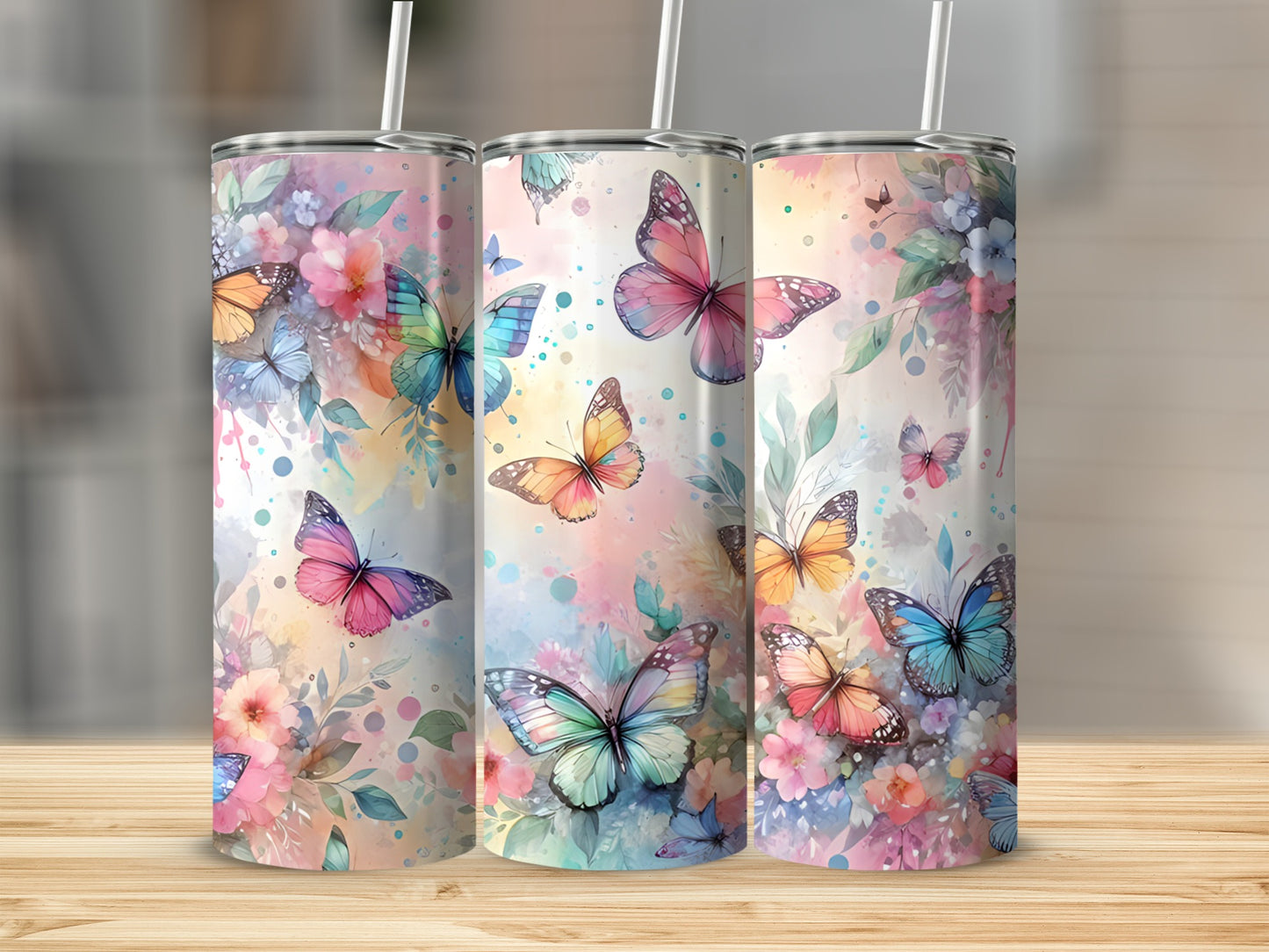 Three tumblers with colorful butterflies and floral designs.