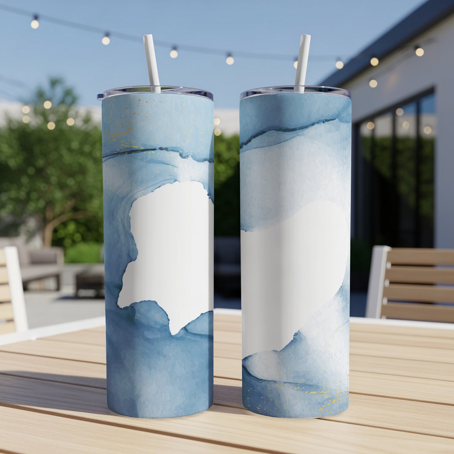 Two blue watercolor tumblers with gold accents on a wooden table.