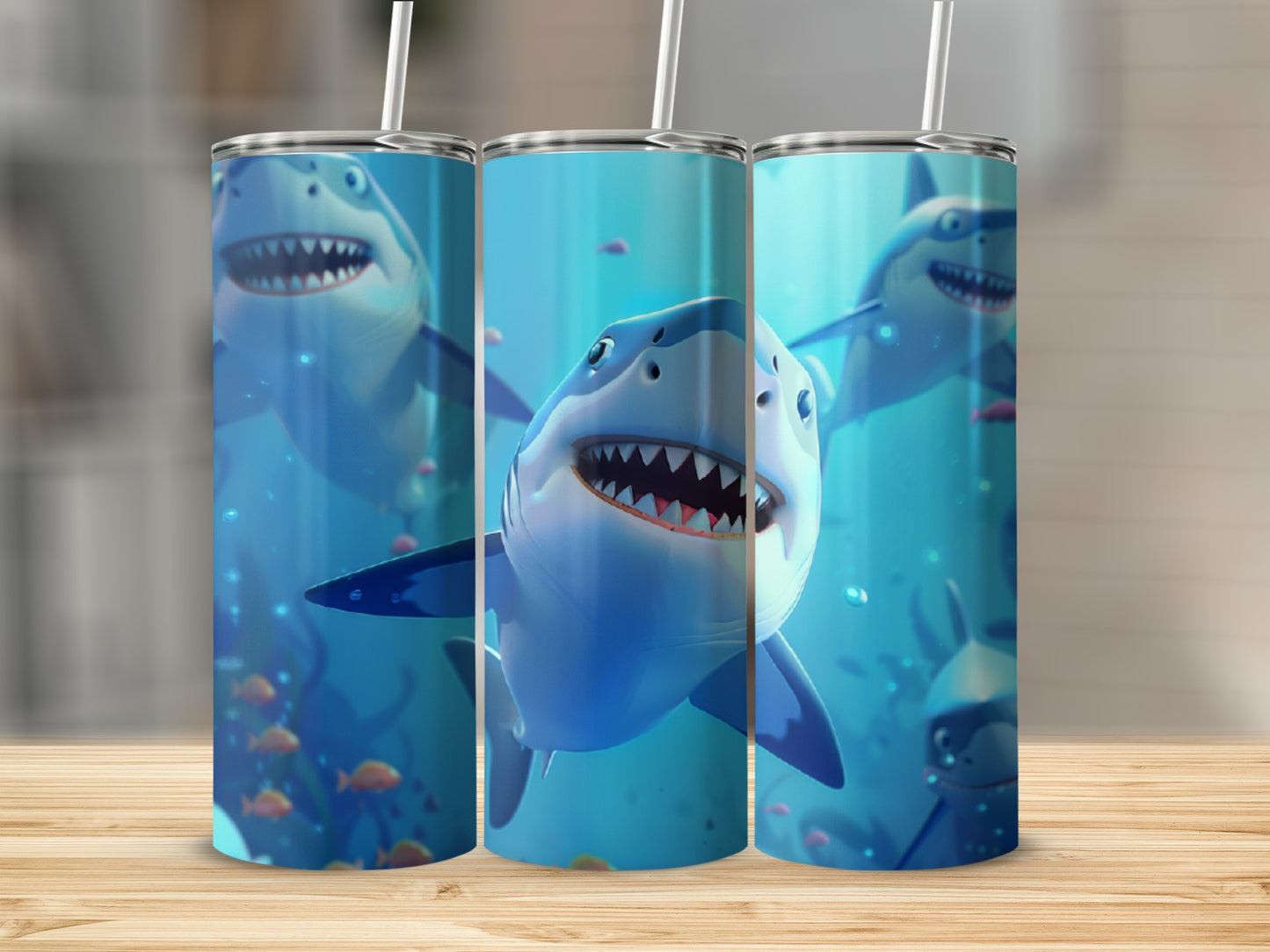 Three tumblers with cartoon sharks and coral on a wooden surface.