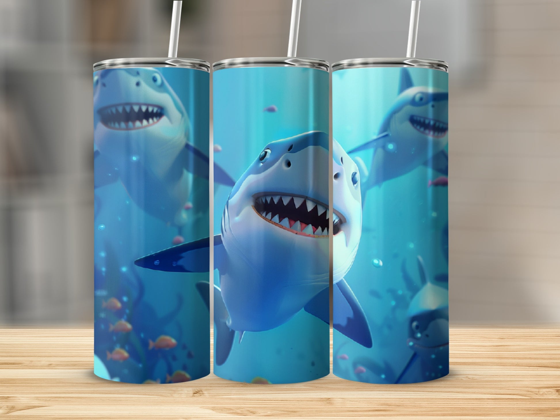 Three tumblers with cartoon sharks and coral on a wooden surface.