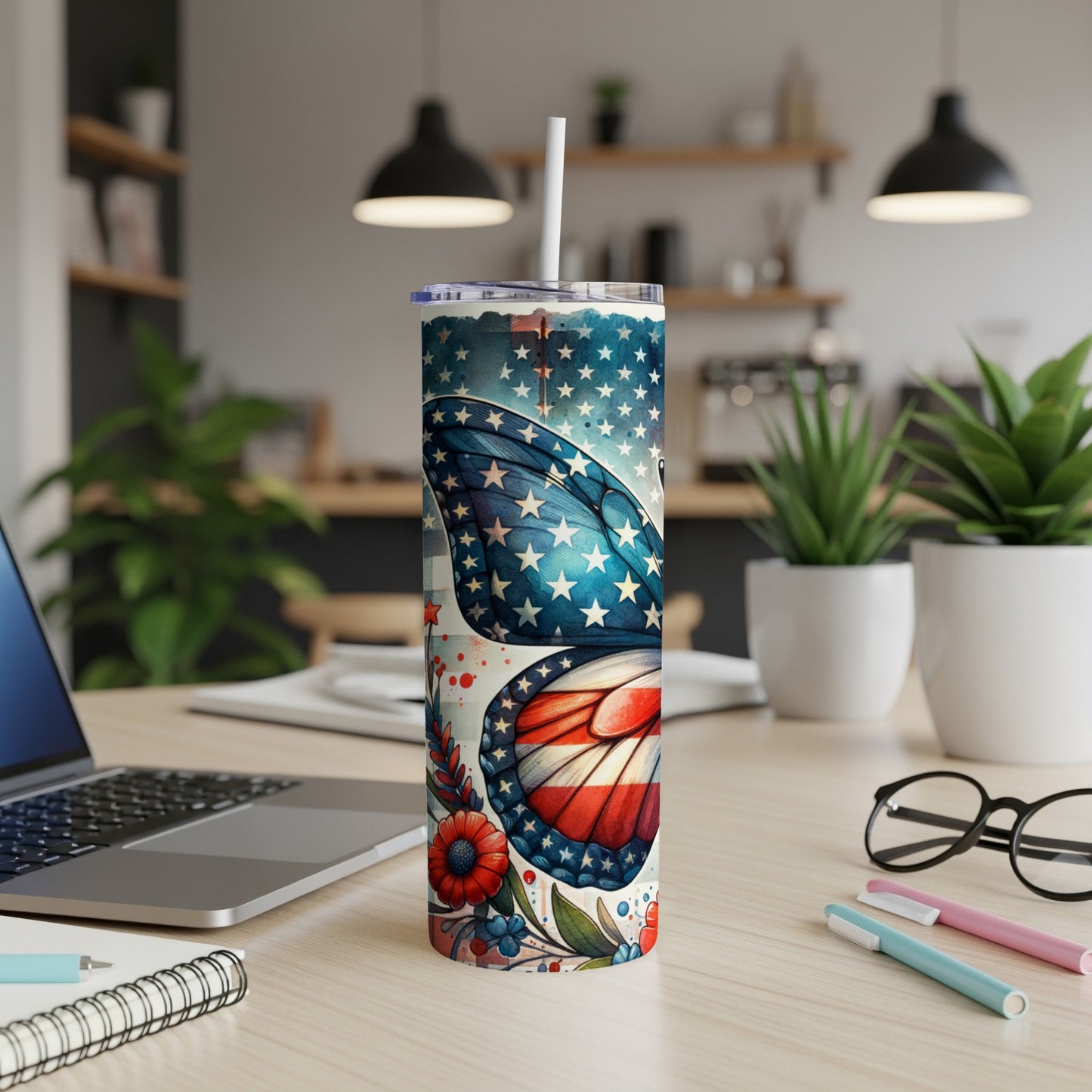 Butterfly patterned tumbler with American flag design on a desk.