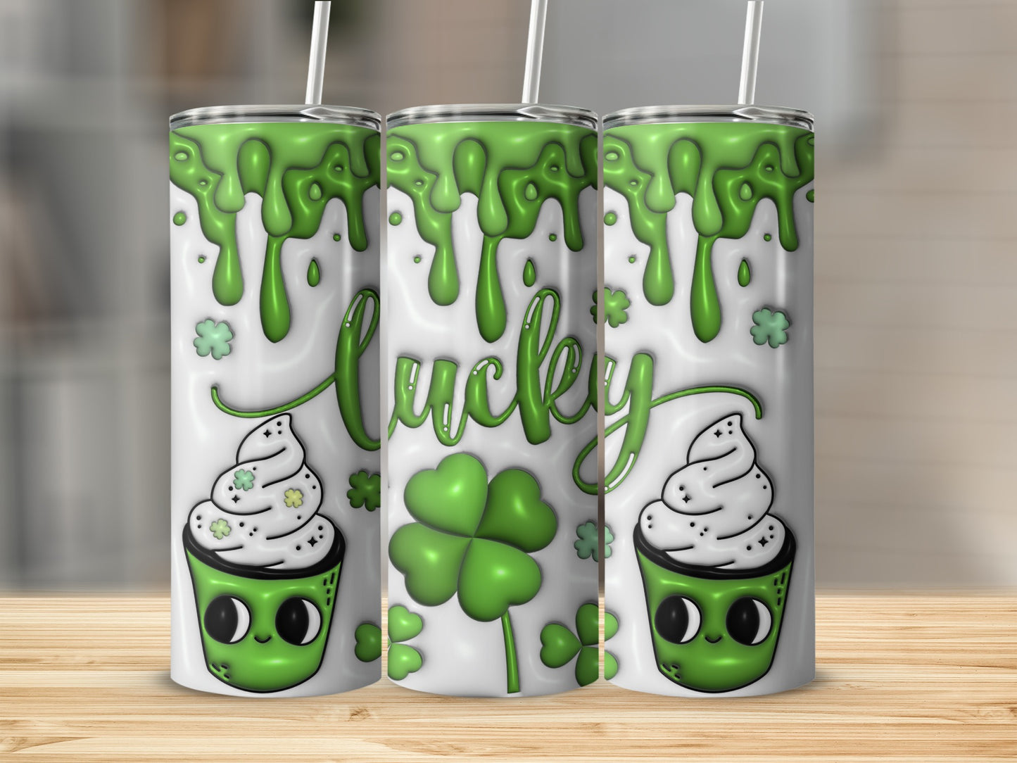 Green lucky clover with dripping slime and cartoon cupcake design on a white tumbler.