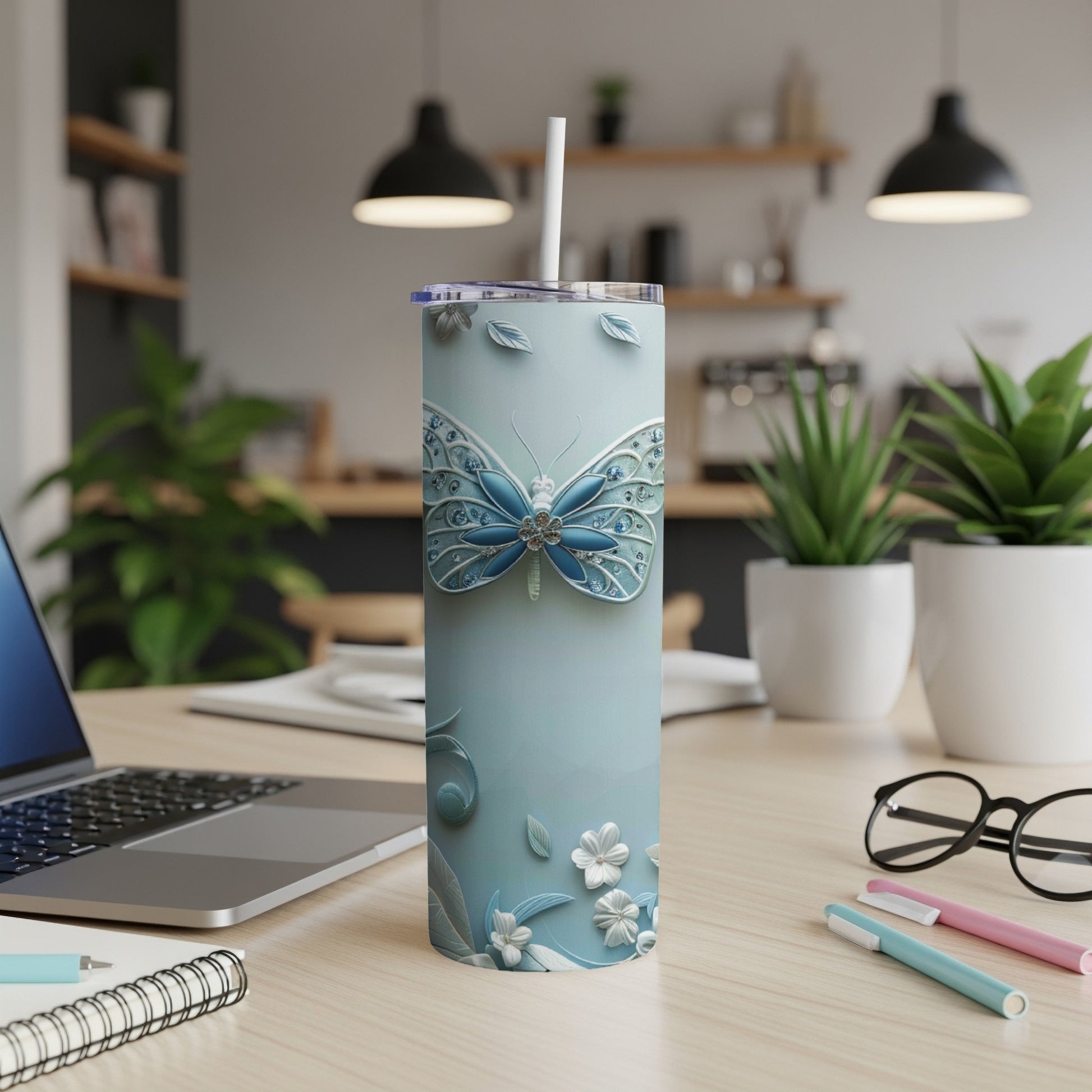 Light blue tumbler with butterfly design, straw, and white flowers.