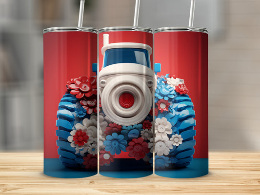 Tractor with patriotic red, white, and blue flowers, on a wooden surface.