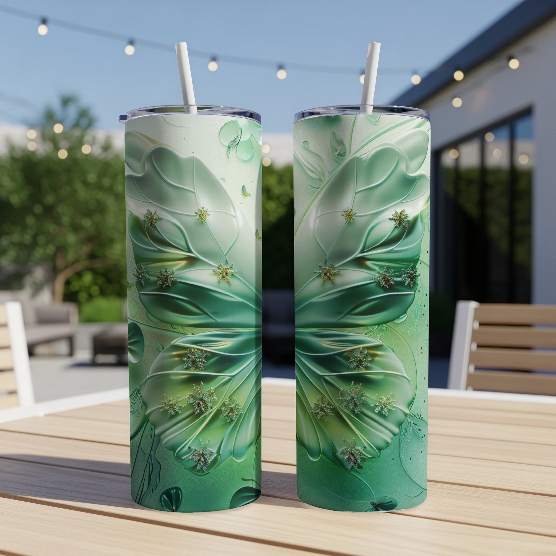 Green butterfly wing design on two tall tumblers with straws.