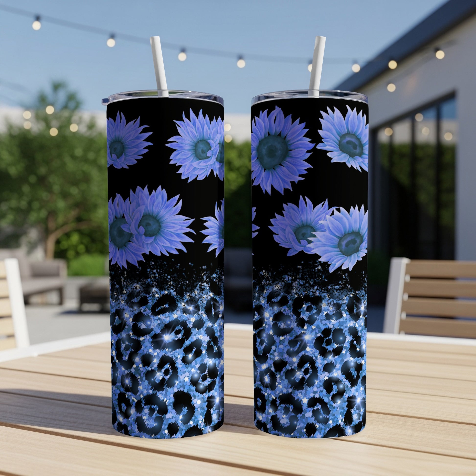 Two blue floral tumblers with leopard print on a table.