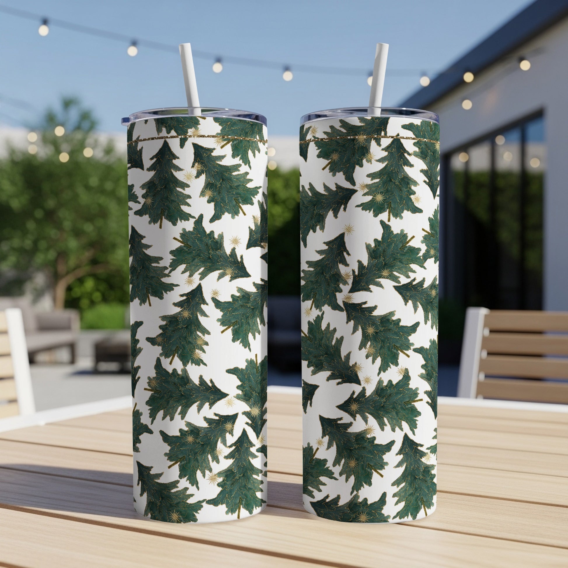 Two patterned tumblers with green Christmas trees and gold stars on a white background.