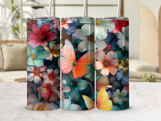 Three tumblers with colorful floral and butterfly designs on a marble surface.