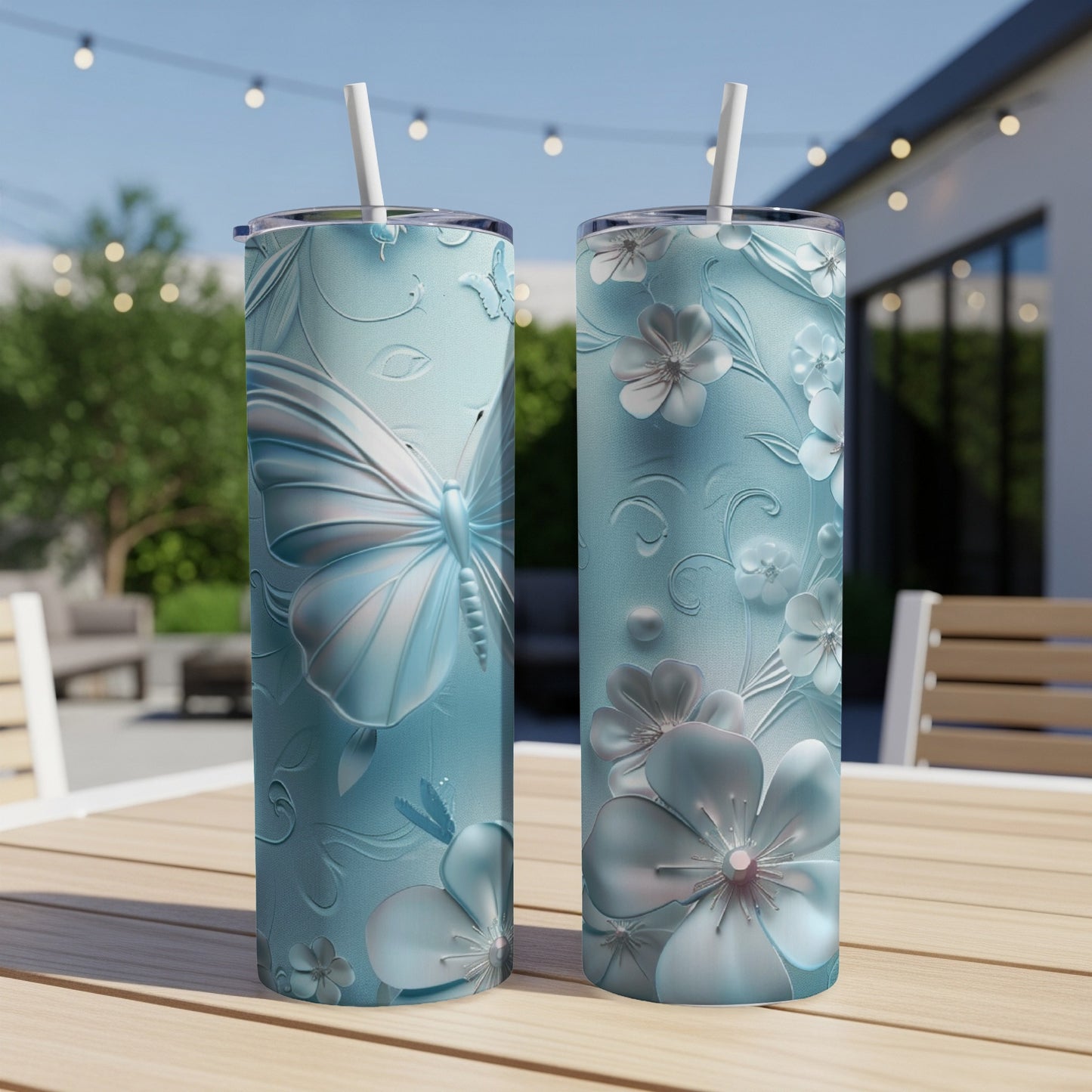 Two blue tumblers with embossed butterflies and floral designs.