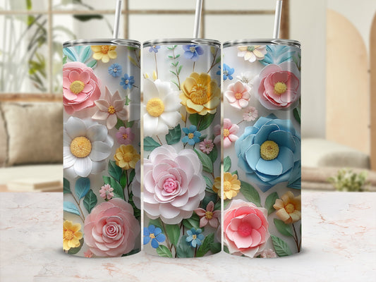Three tumblers adorned with colorful, textured floral designs on a marble surface.